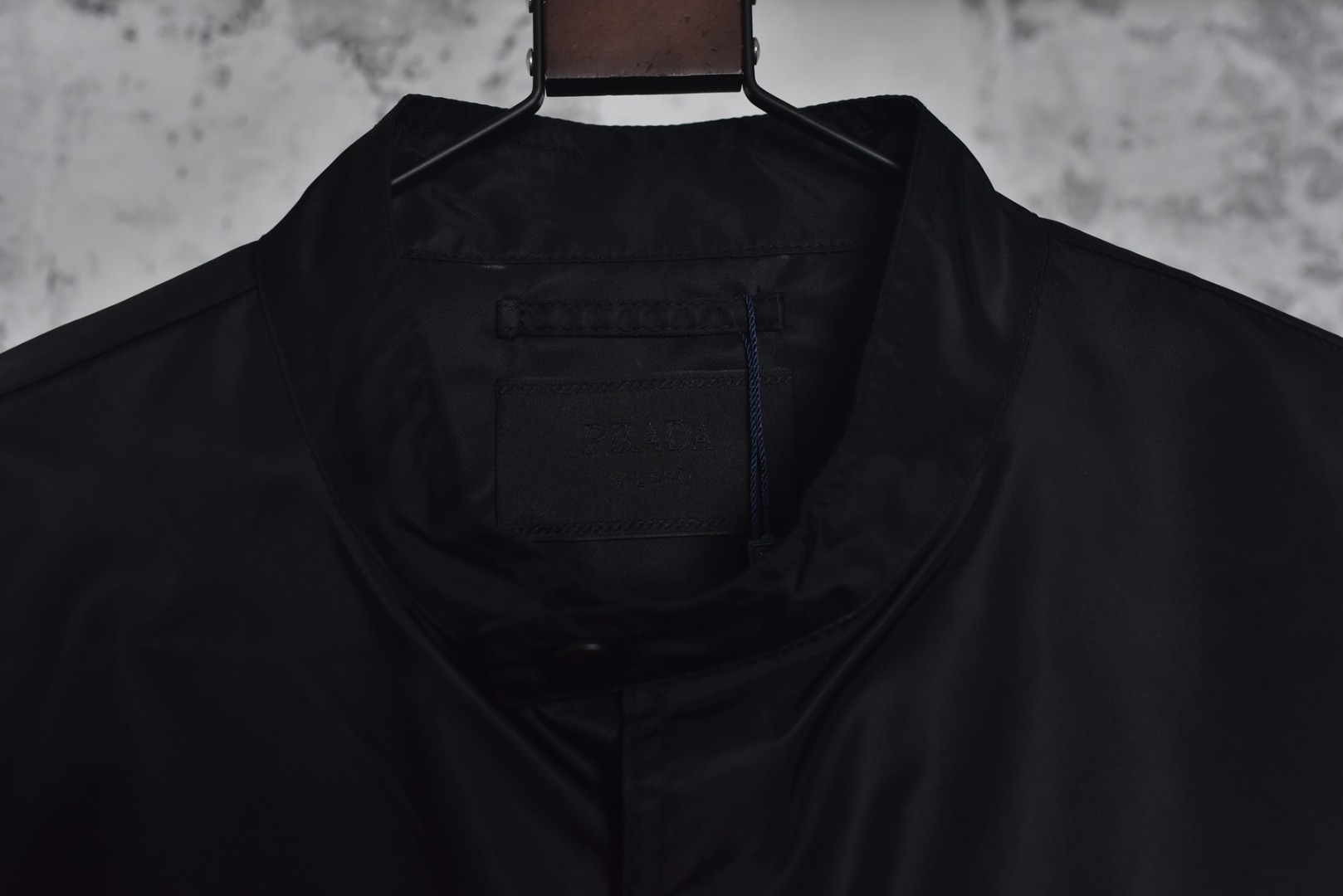 图片[6]-#Prada/普拉达 25Fw 双口袋三角标夹克外套 面料为特殊定制的高密度再生尼龙，并非市场普通现货，其密度、手感与防泼水性能均对标原版，力求还原Re-Nylon材质的轻盈质感与耐磨特性，原版面料重量精密控制在600-800克之间​（视款式而定），本品同样追求这种轻盈与挺括的平衡。所有五金件（包括拉链、扣具等）均源自东莞专业的箱包五金供应商，绝非普通市场通货，五金质感顺滑，经久耐用，拉链头顺滑度优异，减少卡顿感，与原版追求的耐用性一脉相承。胸前标志性的涂珐琅三角形金属徽标，采用的是与原厂（Prada供应商）一致的KF镜面三角标。此徽标由价值千万元的专用机器制作，呈现出镜面效果与清晰字体，细节精度远超市场仿品。原版徽标同样注重质感，其珐琅涂层通过盐雾测试，长期使用不易氧化。三标与洗标均为按原版材质定制，手感与材质均力求一致，确保细节处的正宗感。原版夹克在缝线工艺上采用双层缝线，拼接处使用隐藏式针脚，以提升耐用性和美观性，男女同款 尺码：46 48 50 52-选品中心