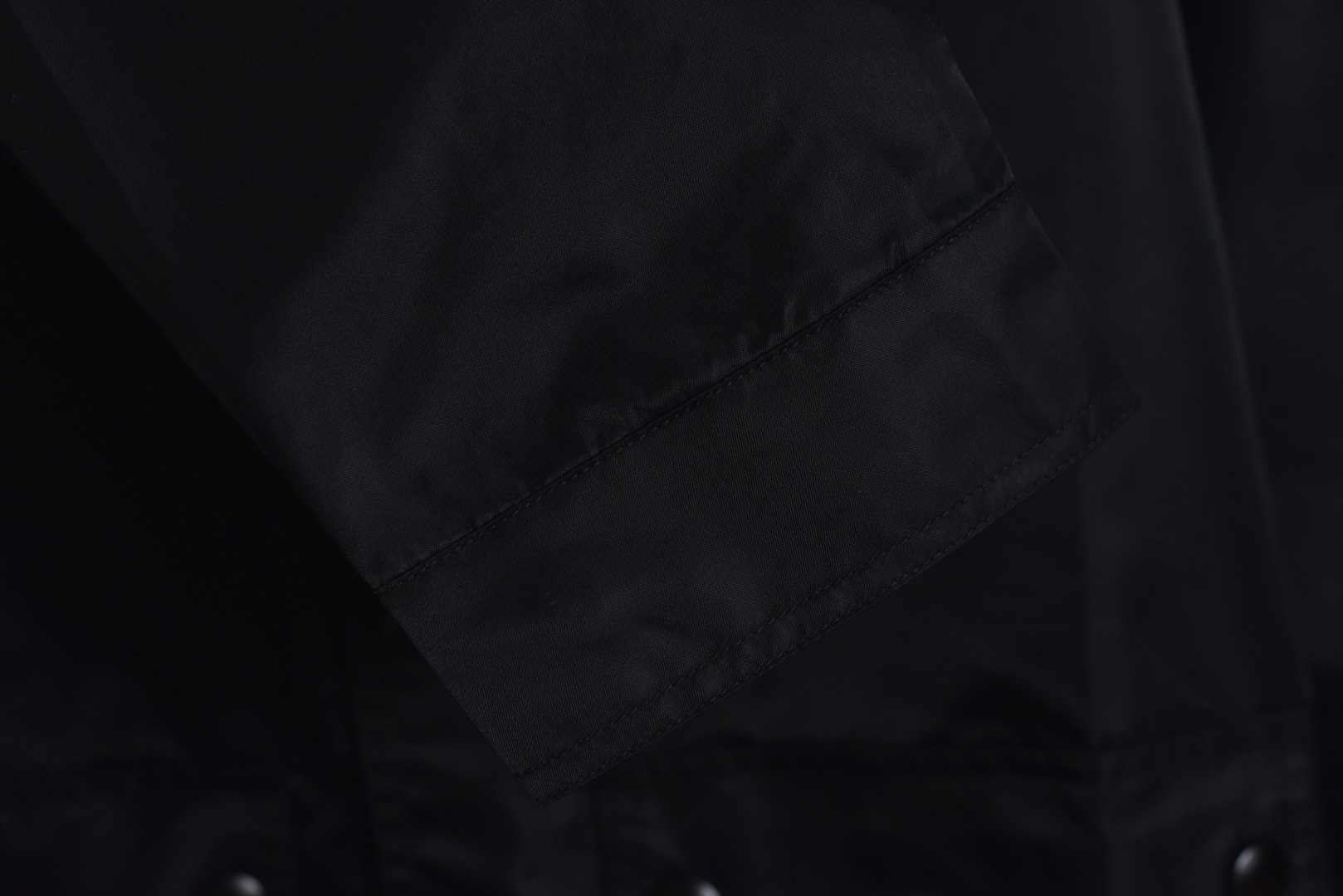 图片[7]-#Prada/普拉达 25Fw 双口袋三角标夹克外套 面料为特殊定制的高密度再生尼龙，并非市场普通现货，其密度、手感与防泼水性能均对标原版，力求还原Re-Nylon材质的轻盈质感与耐磨特性，原版面料重量精密控制在600-800克之间​（视款式而定），本品同样追求这种轻盈与挺括的平衡。所有五金件（包括拉链、扣具等）均源自东莞专业的箱包五金供应商，绝非普通市场通货，五金质感顺滑，经久耐用，拉链头顺滑度优异，减少卡顿感，与原版追求的耐用性一脉相承。胸前标志性的涂珐琅三角形金属徽标，采用的是与原厂（Prada供应商）一致的KF镜面三角标。此徽标由价值千万元的专用机器制作，呈现出镜面效果与清晰字体，细节精度远超市场仿品。原版徽标同样注重质感，其珐琅涂层通过盐雾测试，长期使用不易氧化。三标与洗标均为按原版材质定制，手感与材质均力求一致，确保细节处的正宗感。原版夹克在缝线工艺上采用双层缝线，拼接处使用隐藏式针脚，以提升耐用性和美观性，男女同款 尺码：46 48 50 52-选品中心