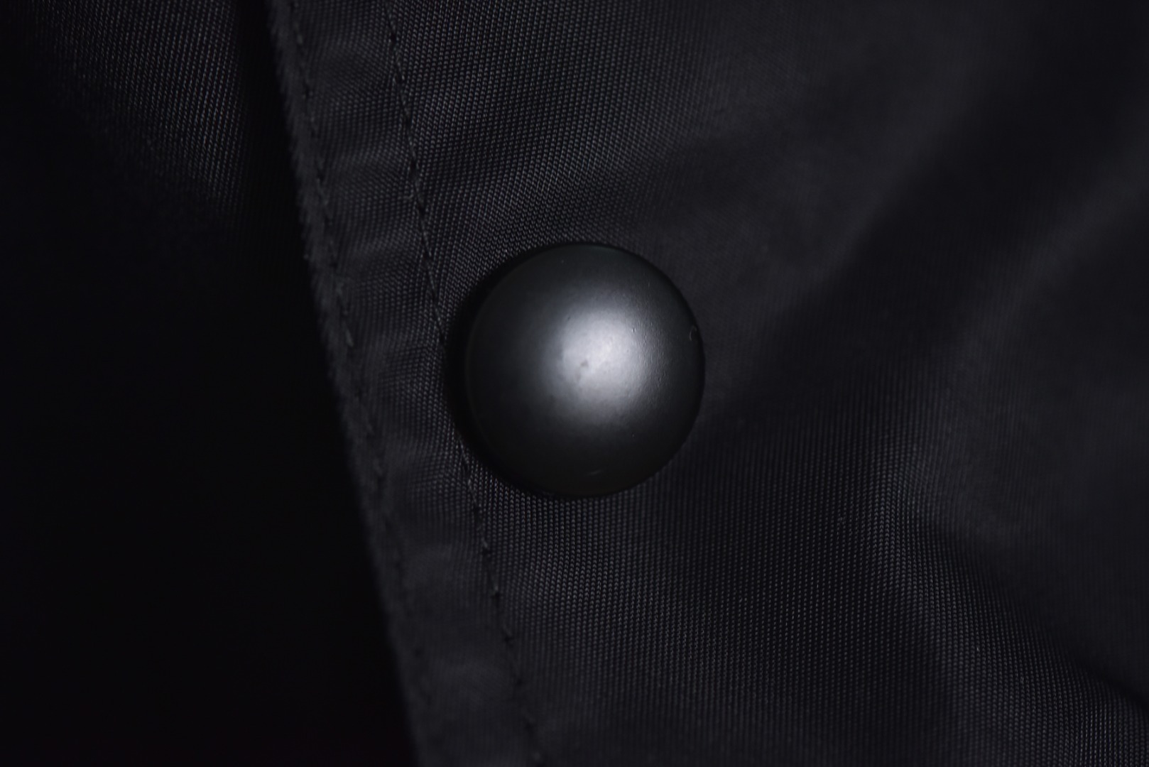 图片[8]-#Prada/普拉达 25Fw 双口袋三角标夹克外套 面料为特殊定制的高密度再生尼龙，并非市场普通现货，其密度、手感与防泼水性能均对标原版，力求还原Re-Nylon材质的轻盈质感与耐磨特性，原版面料重量精密控制在600-800克之间​（视款式而定），本品同样追求这种轻盈与挺括的平衡。所有五金件（包括拉链、扣具等）均源自东莞专业的箱包五金供应商，绝非普通市场通货，五金质感顺滑，经久耐用，拉链头顺滑度优异，减少卡顿感，与原版追求的耐用性一脉相承。胸前标志性的涂珐琅三角形金属徽标，采用的是与原厂（Prada供应商）一致的KF镜面三角标。此徽标由价值千万元的专用机器制作，呈现出镜面效果与清晰字体，细节精度远超市场仿品。原版徽标同样注重质感，其珐琅涂层通过盐雾测试，长期使用不易氧化。三标与洗标均为按原版材质定制，手感与材质均力求一致，确保细节处的正宗感。原版夹克在缝线工艺上采用双层缝线，拼接处使用隐藏式针脚，以提升耐用性和美观性，男女同款 尺码：46 48 50 52-选品中心