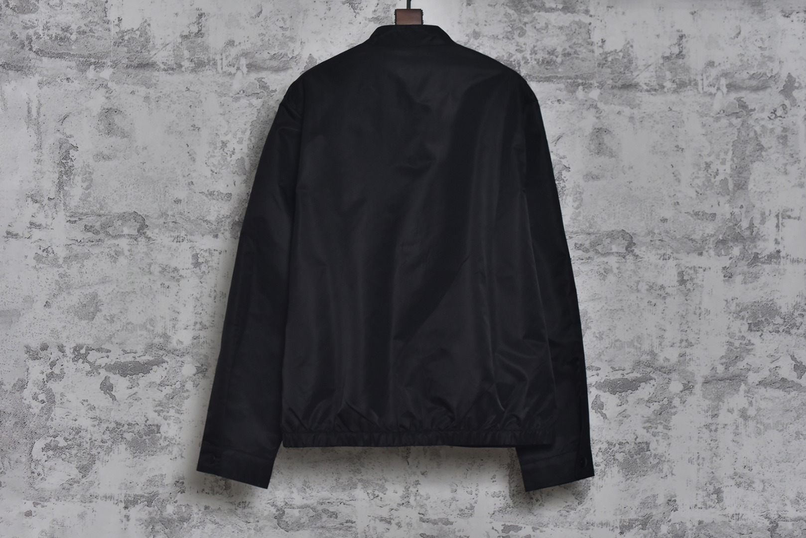 图片[2]-#Prada/普拉达 25Fw 双口袋三角标夹克外套 面料为特殊定制的高密度再生尼龙，并非市场普通现货，其密度、手感与防泼水性能均对标原版，力求还原Re-Nylon材质的轻盈质感与耐磨特性，原版面料重量精密控制在600-800克之间​（视款式而定），本品同样追求这种轻盈与挺括的平衡。所有五金件（包括拉链、扣具等）均源自东莞专业的箱包五金供应商，绝非普通市场通货，五金质感顺滑，经久耐用，拉链头顺滑度优异，减少卡顿感，与原版追求的耐用性一脉相承。胸前标志性的涂珐琅三角形金属徽标，采用的是与原厂（Prada供应商）一致的KF镜面三角标。此徽标由价值千万元的专用机器制作，呈现出镜面效果与清晰字体，细节精度远超市场仿品。原版徽标同样注重质感，其珐琅涂层通过盐雾测试，长期使用不易氧化。三标与洗标均为按原版材质定制，手感与材质均力求一致，确保细节处的正宗感。原版夹克在缝线工艺上采用双层缝线，拼接处使用隐藏式针脚，以提升耐用性和美观性，男女同款 尺码：46 48 50 52-选品中心