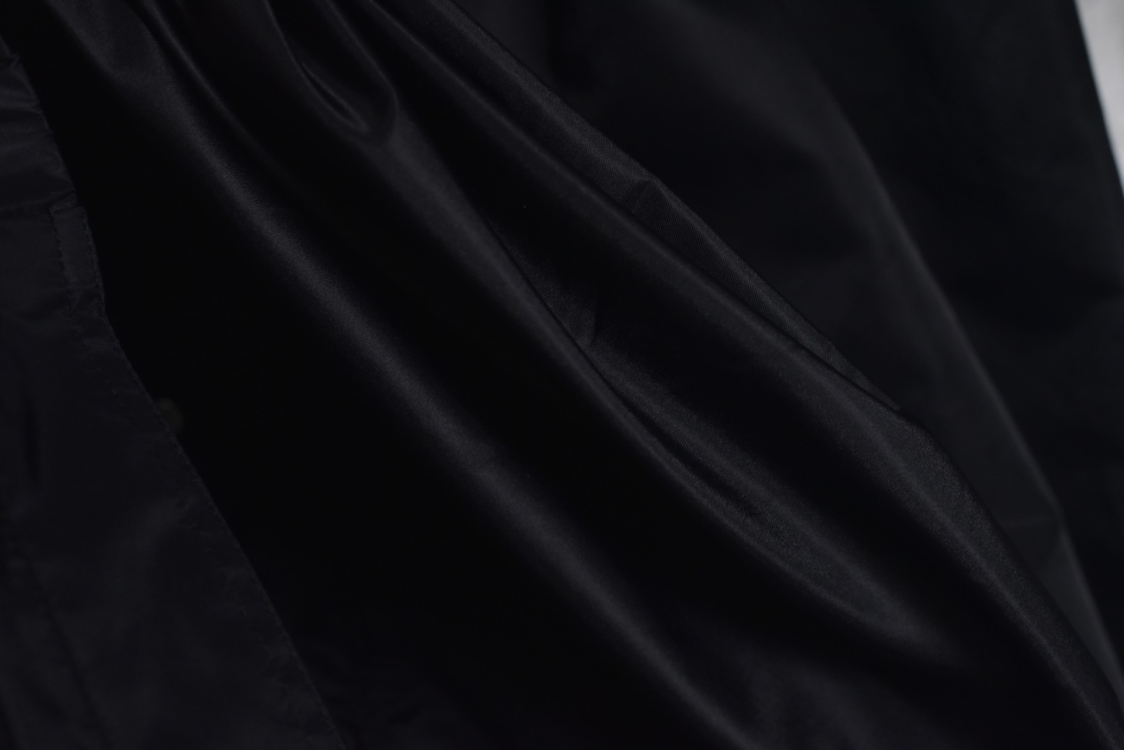 图片[9]-#Prada/普拉达 25Fw 双口袋三角标夹克外套 面料为特殊定制的高密度再生尼龙，并非市场普通现货，其密度、手感与防泼水性能均对标原版，力求还原Re-Nylon材质的轻盈质感与耐磨特性，原版面料重量精密控制在600-800克之间​（视款式而定），本品同样追求这种轻盈与挺括的平衡。所有五金件（包括拉链、扣具等）均源自东莞专业的箱包五金供应商，绝非普通市场通货，五金质感顺滑，经久耐用，拉链头顺滑度优异，减少卡顿感，与原版追求的耐用性一脉相承。胸前标志性的涂珐琅三角形金属徽标，采用的是与原厂（Prada供应商）一致的KF镜面三角标。此徽标由价值千万元的专用机器制作，呈现出镜面效果与清晰字体，细节精度远超市场仿品。原版徽标同样注重质感，其珐琅涂层通过盐雾测试，长期使用不易氧化。三标与洗标均为按原版材质定制，手感与材质均力求一致，确保细节处的正宗感。原版夹克在缝线工艺上采用双层缝线，拼接处使用隐藏式针脚，以提升耐用性和美观性，男女同款 尺码：46 48 50 52-选品中心