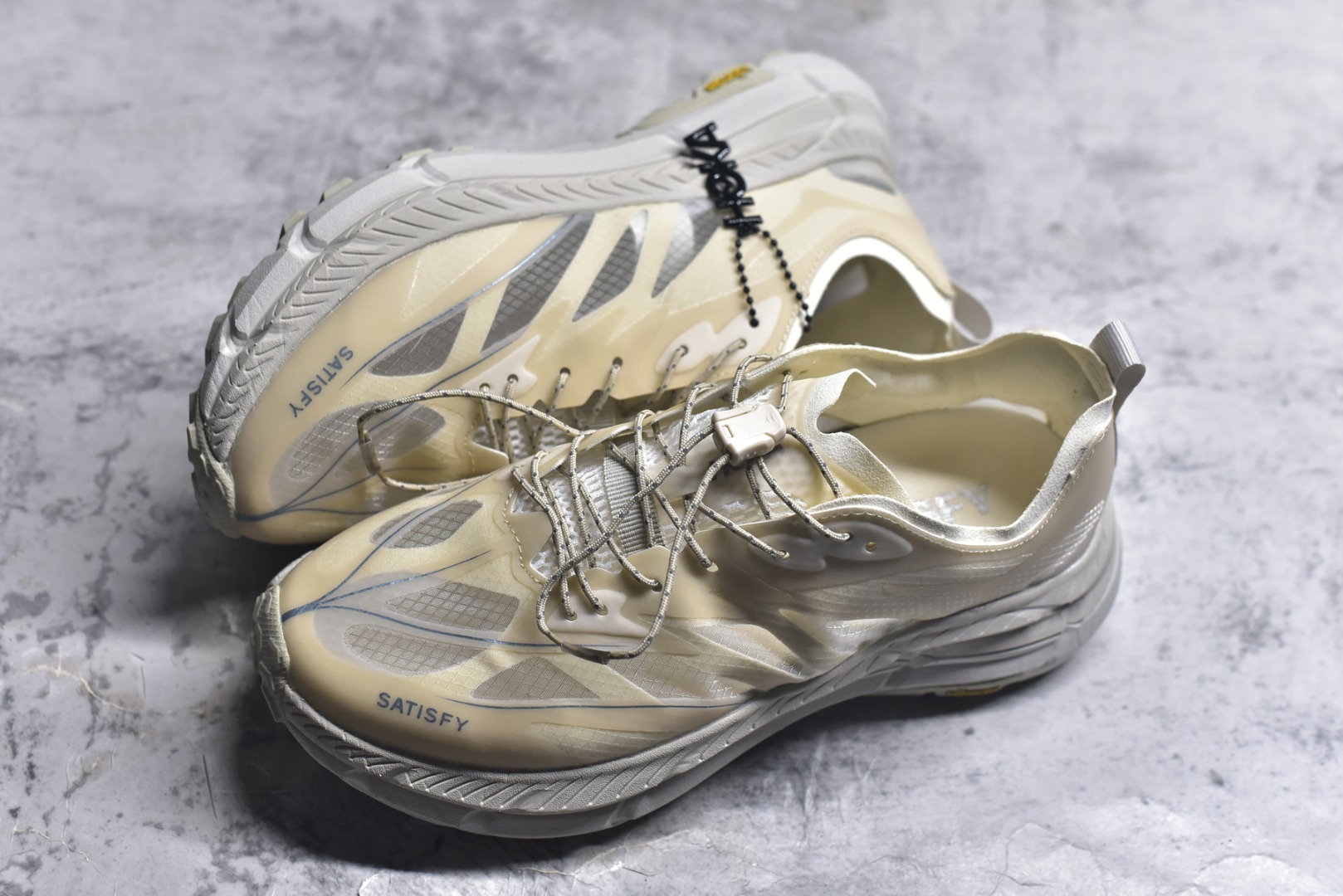 图片[7]-#Satisfy x HOKA ONE ONE 百搭简约防滑耐磨低帮跑步鞋 联名配色 球鞋继承了HOKA的经典越野鞋型MAFATE SPEED 4的设计，更在此基础上进行了创新和提升，使得它既适合户外越野跑，又充满了时尚潮流的元素。它的半透明鞋面设计，不仅让鞋身看起来更加轻便，而且提供了良好的透气性。而保护性的防撕裂尼龙面料，则确保了在复杂地形中的耐用性。这样的设计，让人在享受奔跑的同时，也能感受到鞋底带来的舒适。双层ProFly™中底的使用，是这款鞋的另一个亮点。这种中底材质，提供了卓越的缓震性能，无论是在崎岖的山路上，还是在平坦的道路上，都能给跑者带来稳定的支撑。而VIBRAM MEGAGRIP®及LITEBASE®大底的搭载，更是让这款鞋在保持高抓地力的同时，减轻了鞋底的重量，使得每一步跑动都轻盈如飞。尺码：36 36.5 37.5 38 38.5 39 40 40.5 41 42 42.5 43 44 45-选品中心