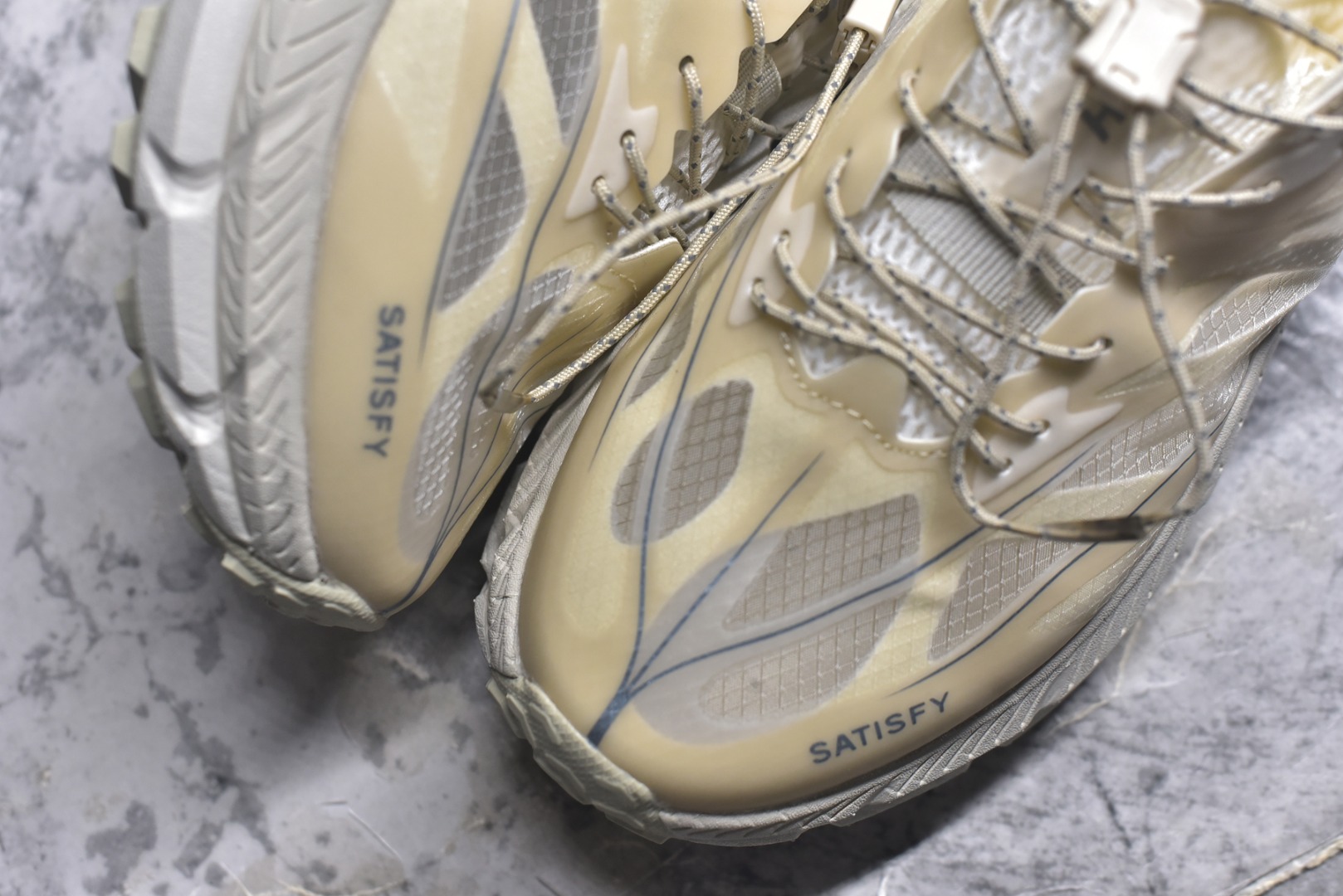 图片[8]-#Satisfy x HOKA ONE ONE 百搭简约防滑耐磨低帮跑步鞋 联名配色 球鞋继承了HOKA的经典越野鞋型MAFATE SPEED 4的设计，更在此基础上进行了创新和提升，使得它既适合户外越野跑，又充满了时尚潮流的元素。它的半透明鞋面设计，不仅让鞋身看起来更加轻便，而且提供了良好的透气性。而保护性的防撕裂尼龙面料，则确保了在复杂地形中的耐用性。这样的设计，让人在享受奔跑的同时，也能感受到鞋底带来的舒适。双层ProFly™中底的使用，是这款鞋的另一个亮点。这种中底材质，提供了卓越的缓震性能，无论是在崎岖的山路上，还是在平坦的道路上，都能给跑者带来稳定的支撑。而VIBRAM MEGAGRIP®及LITEBASE®大底的搭载，更是让这款鞋在保持高抓地力的同时，减轻了鞋底的重量，使得每一步跑动都轻盈如飞。尺码：36 36.5 37.5 38 38.5 39 40 40.5 41 42 42.5 43 44 45-选品中心