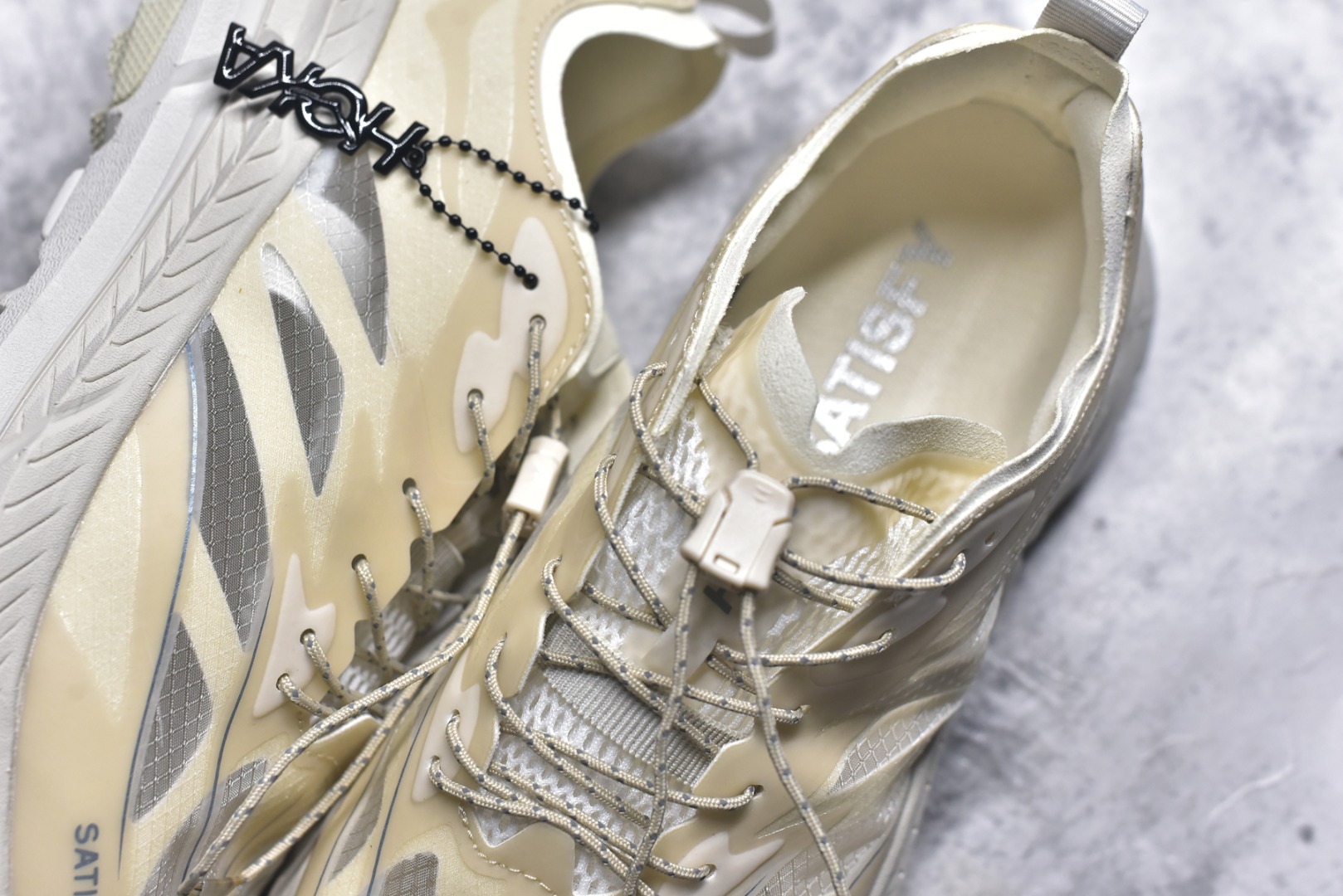 图片[9]-#Satisfy x HOKA ONE ONE 百搭简约防滑耐磨低帮跑步鞋 联名配色 球鞋继承了HOKA的经典越野鞋型MAFATE SPEED 4的设计，更在此基础上进行了创新和提升，使得它既适合户外越野跑，又充满了时尚潮流的元素。它的半透明鞋面设计，不仅让鞋身看起来更加轻便，而且提供了良好的透气性。而保护性的防撕裂尼龙面料，则确保了在复杂地形中的耐用性。这样的设计，让人在享受奔跑的同时，也能感受到鞋底带来的舒适。双层ProFly™中底的使用，是这款鞋的另一个亮点。这种中底材质，提供了卓越的缓震性能，无论是在崎岖的山路上，还是在平坦的道路上，都能给跑者带来稳定的支撑。而VIBRAM MEGAGRIP®及LITEBASE®大底的搭载，更是让这款鞋在保持高抓地力的同时，减轻了鞋底的重量，使得每一步跑动都轻盈如飞。尺码：36 36.5 37.5 38 38.5 39 40 40.5 41 42 42.5 43 44 45-选品中心