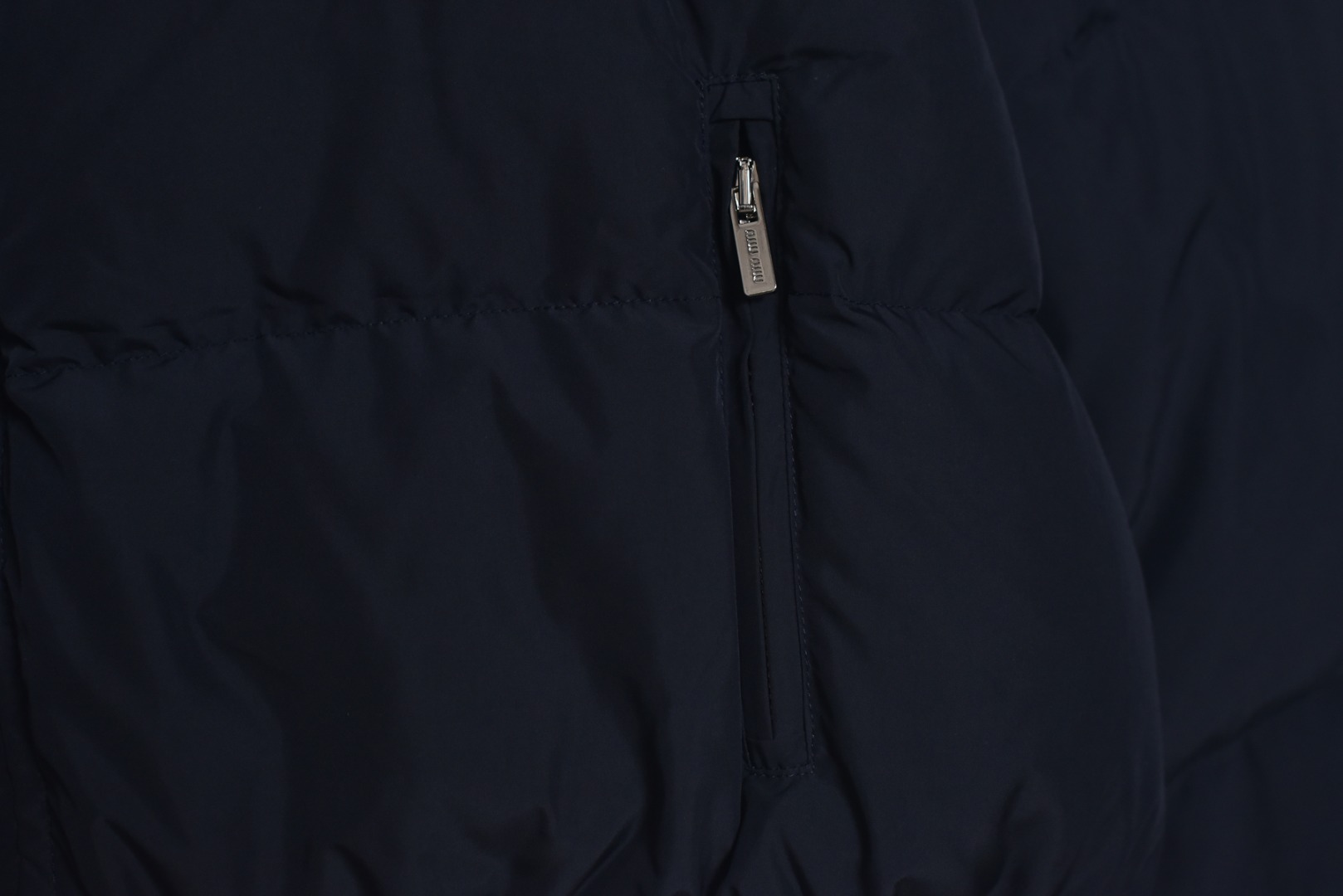 图片[5]-#Miu Miu 25Fw Miu小标捆条短款羽绒服 -核心内里填充180G广检认证90%纯白鸭绒 定制开发高支高密梭织面料，其纱线结构与织法经过精密计算，旨在实现极佳的防绒钻性，同时保证面料本身的轻盈与耐久度，面料色彩为独家定染，确保了色彩的纯粹度与独特性，采用捆条拼接工艺，该工艺在每块裁片的接缝处内衬一条白色织带，再将面料拼接并压线固定，白色的捆条在深色面料上形成了鲜明而利落的轮廓线，强化了单品的结构化视觉，内里填充90白鸭绒，高纯度绒子能锁住大量空气，形成静止空气层，实现高效保暖，这使得羽绒服在拥有极强保暖性的同时，重量得以大幅减轻，选用进口电脑充绒设备，确保每一个独立绗格内的羽绒填充量都精准、均匀，避免出现局部空洞或结块，从而保证羽绒服整体的平整度、保暖均匀性与持久蓬松，定制辅料三标 尺码：38 40 42-选品中心