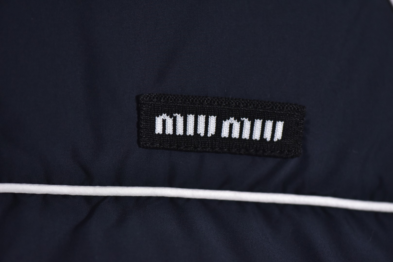 图片[6]-#Miu Miu 25Fw Miu小标捆条短款羽绒服 -核心内里填充180G广检认证90%纯白鸭绒 定制开发高支高密梭织面料，其纱线结构与织法经过精密计算，旨在实现极佳的防绒钻性，同时保证面料本身的轻盈与耐久度，面料色彩为独家定染，确保了色彩的纯粹度与独特性，采用捆条拼接工艺，该工艺在每块裁片的接缝处内衬一条白色织带，再将面料拼接并压线固定，白色的捆条在深色面料上形成了鲜明而利落的轮廓线，强化了单品的结构化视觉，内里填充90白鸭绒，高纯度绒子能锁住大量空气，形成静止空气层，实现高效保暖，这使得羽绒服在拥有极强保暖性的同时，重量得以大幅减轻，选用进口电脑充绒设备，确保每一个独立绗格内的羽绒填充量都精准、均匀，避免出现局部空洞或结块，从而保证羽绒服整体的平整度、保暖均匀性与持久蓬松，定制辅料三标 尺码：38 40 42-选品中心