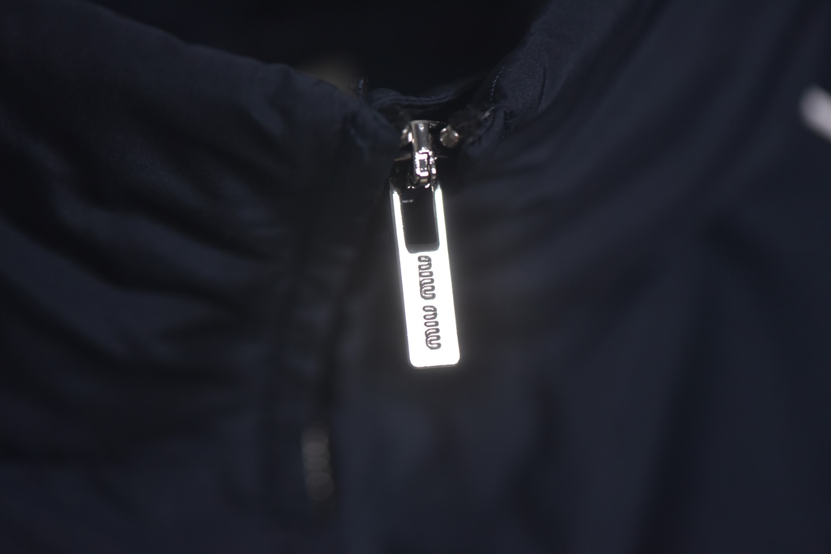 图片[3]-#Miu Miu 25Fw Miu小标捆条短款羽绒服 -核心内里填充180G广检认证90%纯白鸭绒 定制开发高支高密梭织面料，其纱线结构与织法经过精密计算，旨在实现极佳的防绒钻性，同时保证面料本身的轻盈与耐久度，面料色彩为独家定染，确保了色彩的纯粹度与独特性，采用捆条拼接工艺，该工艺在每块裁片的接缝处内衬一条白色织带，再将面料拼接并压线固定，白色的捆条在深色面料上形成了鲜明而利落的轮廓线，强化了单品的结构化视觉，内里填充90白鸭绒，高纯度绒子能锁住大量空气，形成静止空气层，实现高效保暖，这使得羽绒服在拥有极强保暖性的同时，重量得以大幅减轻，选用进口电脑充绒设备，确保每一个独立绗格内的羽绒填充量都精准、均匀，避免出现局部空洞或结块，从而保证羽绒服整体的平整度、保暖均匀性与持久蓬松，定制辅料三标 尺码：38 40 42-选品中心