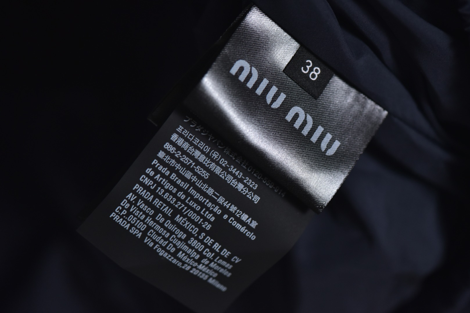 图片[8]-#Miu Miu 25Fw Miu小标捆条短款羽绒服 -核心内里填充180G广检认证90%纯白鸭绒 定制开发高支高密梭织面料，其纱线结构与织法经过精密计算，旨在实现极佳的防绒钻性，同时保证面料本身的轻盈与耐久度，面料色彩为独家定染，确保了色彩的纯粹度与独特性，采用捆条拼接工艺，该工艺在每块裁片的接缝处内衬一条白色织带，再将面料拼接并压线固定，白色的捆条在深色面料上形成了鲜明而利落的轮廓线，强化了单品的结构化视觉，内里填充90白鸭绒，高纯度绒子能锁住大量空气，形成静止空气层，实现高效保暖，这使得羽绒服在拥有极强保暖性的同时，重量得以大幅减轻，选用进口电脑充绒设备，确保每一个独立绗格内的羽绒填充量都精准、均匀，避免出现局部空洞或结块，从而保证羽绒服整体的平整度、保暖均匀性与持久蓬松，定制辅料三标 尺码：38 40 42-选品中心