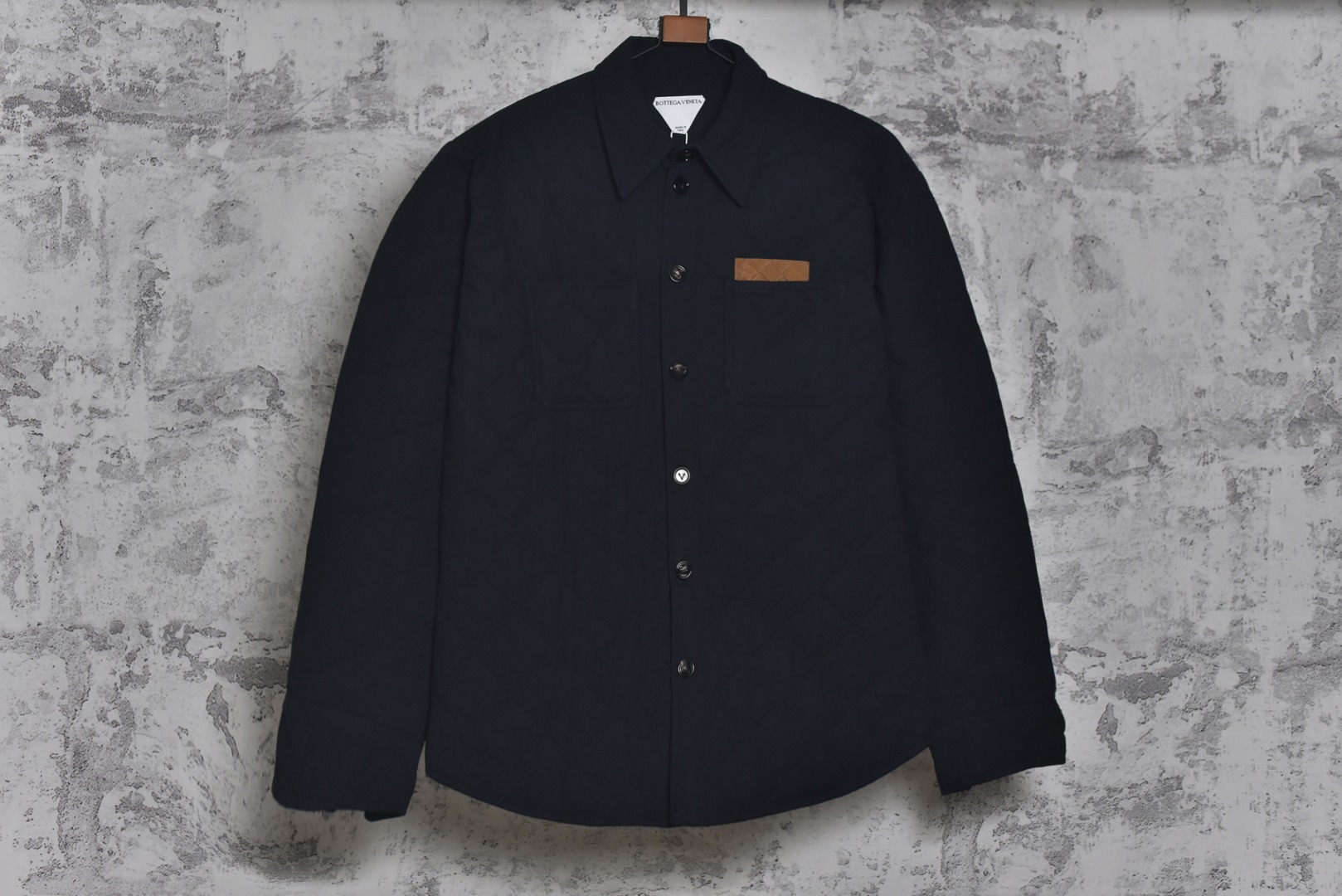 #BV 25Fw 口袋皮标菱格绗线棉服外套 定织全澳漂白精梳棉，在纺纱前，经过精梳工序来剔除短绒纤维与杂质，只保留最长的优质棉纤维，这使得最终织成的面料纹理极度清晰、表面光洁平滑，且具备抗起球性与耐久度，采用精准控制的漂白工艺，并非追求刺眼的亮白，而是达成一种温润、纯粹的中性本白色调，凸显其立体感与高级质感，面料表面的菱形格纹通过极为复杂的多层绗缝工艺实现，它将表层澳棉面料、中间层保暖填充物与内里三层复合，菱形格纹都要求精准的对位与缝线，缝线针距均匀密实，在塑造经典“绗缝”外观的同时，确保了填充物固定不移位，从而形成一个个微型的气室结构，在轻盈无重感的穿着体验中，实现出色的锁温效果，胸前口袋处定制真皮皮革，这款皮革经过特殊鞣制与处理，呈现出细腻柔韧的触感和自然的光泽，每一颗纽扣均采用天然牛角经全手工打磨而成，牛角材质的独特之处在于其温润的质感、不规则的天然纹理与半通透的色泽，定制辅料三标，男女同款 尺码：46 48 50-选品中心