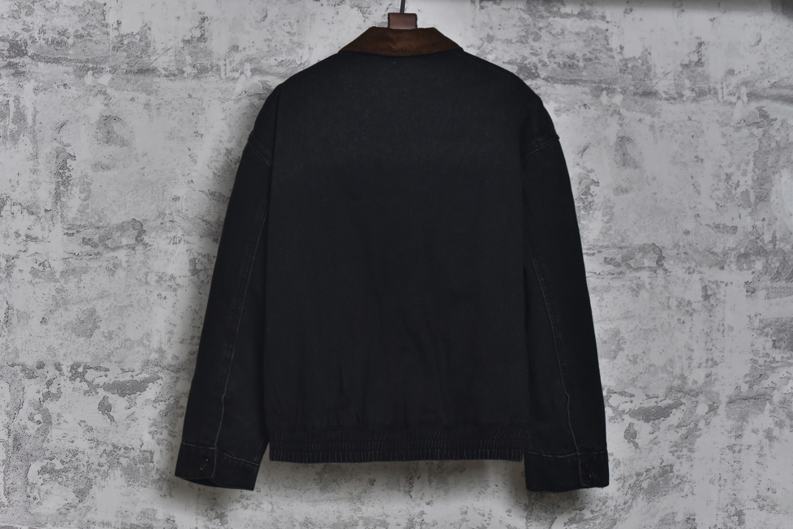 图片[2]-#Miu Miu 25Fw Miu小标牛仔棉服外套 选用高克重100%棉制牛仔斜纹布，高克重意味着面料单位面积密度更高，这不仅赋予了服装卓越的耐用性与抗皱性，更关键的是，它能自然支撑起利落而硬挺的立体廓形，无需依赖额外的内衬，面料经过专业的洗水处理，通过精准控制的酶洗、石磨等工艺，软化了原生棉布的僵硬感，使其触感更为亲肤柔顺。同时，这一过程赋予了丹宁独特的落色效果与微妙的复古做旧纹理，领部采用100%纯棉粗棱灯芯绒，其独特的瓦楞状脊线纹理与主体丹宁的斜纹肌理形成强烈而巧妙的视觉与触觉对比，将柔软且结构相对松散的灯芯绒与硬挺的牛仔布进行拼接，需要极高的裁切与缝纫精度，以确保接缝处平整牢固，避免因材质缩率不同而产生的变形。此举体现了品牌对异材质拼接工艺的成熟掌控，内里填充1400D高密度洗水棉。这里的“D”并非填充重量，而是指棉絮本身的纤维细度与长度规格，其拥有极佳的蓬松度与持久性，不易结块或移位，能确保夹克长期使用后仍保持均匀平整的保暖层，结合高克重牛仔布形成的“外壳结构”，共同构建了一个轻量却高效的隔热系统，实现了保暖性与廓形感的统一，在左前幅，运用了极为精细的真皮激光镭射雕花工艺。首先将一块小牛皮复合于面料之上，随后通过高精度激光按照预设图案进行烧蚀，刻画出品牌标识或图案，此工艺要求对激光的功率与速度进行毫厘不差的控制，才能在皮革上实现边缘锐利、细节分明的图案，同时不伤及底层的丹宁面料，定制辅料三标，男女同款 尺码：40 42 44-选品中心