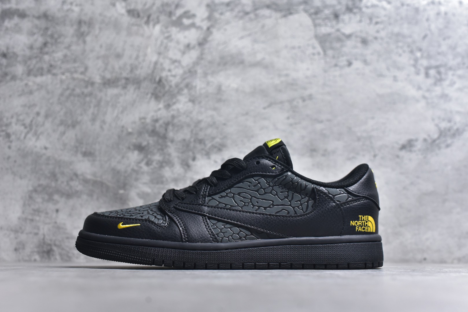 #当 Air Jordan 1 Low 携手 The North Face 掀起跨界风暴，直接把机能与街头的融合玩到极致。全黑鞋身以荔枝纹皮革为基底，鞋侧与鞋头的爆裂纹理暗藏野性，金色 Swoosh 小勾与鞋身的 THE NORTH FACE 字母标识形成亮眼撞色，低调中透着奢华质感。经典的 AJ1 Low 鞋型搭配 TNF 的户外基因，不仅延续了标志性的低帮利落线条，更让这双鞋成为街头穿搭与户外风格的通吃款。从鞋舌的荧光黄细节到全黑橡胶大底的扎实脚感，每一处设计都在诠释硬核联名的魅力，潮酷玩家直接锁死这双宝藏款！货号：DZ5899-043-选品中心
