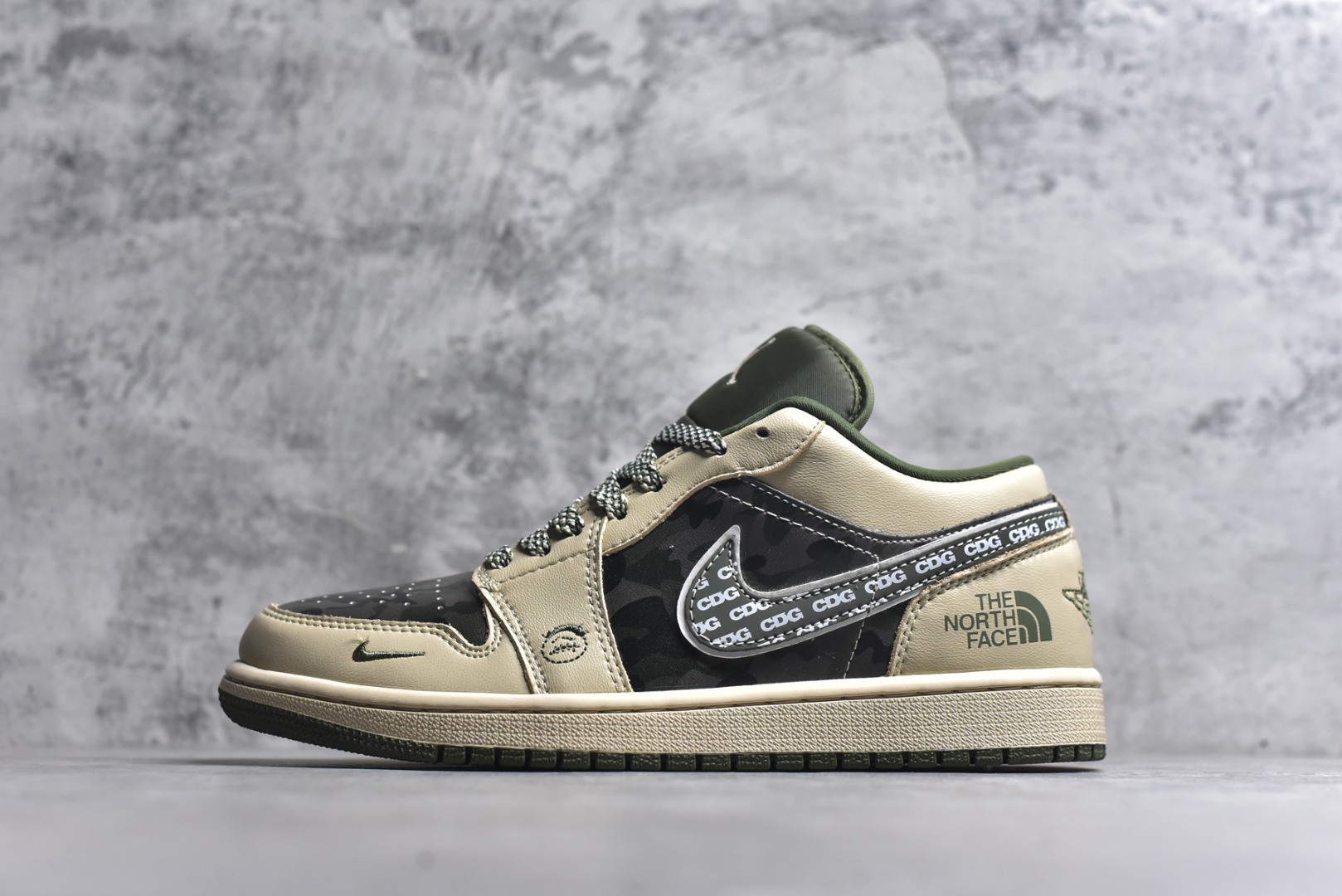 #Air Jordan 1 Low x 北面 x CDG 联名款｜野性与潮流的碰撞。当飞人图腾邂逅户外传奇，再融合先锋时尚的基因，这双Air Jordan 1 Low QG1988-017直接把跨界联名的质感拉满！浅卡其色鞋身搭配墨绿迷彩拼接，皮革与耐磨材质的碰撞，既有AJ1经典的复古轮廓，又注入了The North Face的户外硬核气质。鞋侧Swoosh满印CDG标识，后跟北面logo醒目点缀，三重品牌元素的融合毫不违和，每一处细节都透着潮流与机能的双重魅力。粗织鞋带、撞色包边的设计，让这双鞋不仅是穿搭利器，更暗藏户外探索的野性；低帮版型兼顾日常上脚的舒适与百搭，不管是街头潮搭还是轻户外造型，都能轻松hold住。这双集AJ的经典、北面的硬核、CDG的先锋于一体的联名款，是潮流玩家和户外爱好者都无法拒绝的收藏级单品！-选品中心