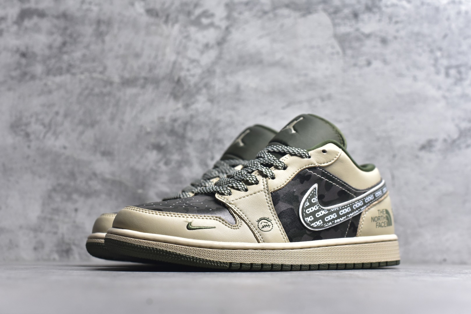 图片[2]-#Air Jordan 1 Low x 北面 x CDG 联名款｜野性与潮流的碰撞。当飞人图腾邂逅户外传奇，再融合先锋时尚的基因，这双Air Jordan 1 Low QG1988-017直接把跨界联名的质感拉满！浅卡其色鞋身搭配墨绿迷彩拼接，皮革与耐磨材质的碰撞，既有AJ1经典的复古轮廓，又注入了The North Face的户外硬核气质。鞋侧Swoosh满印CDG标识，后跟北面logo醒目点缀，三重品牌元素的融合毫不违和，每一处细节都透着潮流与机能的双重魅力。粗织鞋带、撞色包边的设计，让这双鞋不仅是穿搭利器，更暗藏户外探索的野性；低帮版型兼顾日常上脚的舒适与百搭，不管是街头潮搭还是轻户外造型，都能轻松hold住。这双集AJ的经典、北面的硬核、CDG的先锋于一体的联名款，是潮流玩家和户外爱好者都无法拒绝的收藏级单品！-选品中心