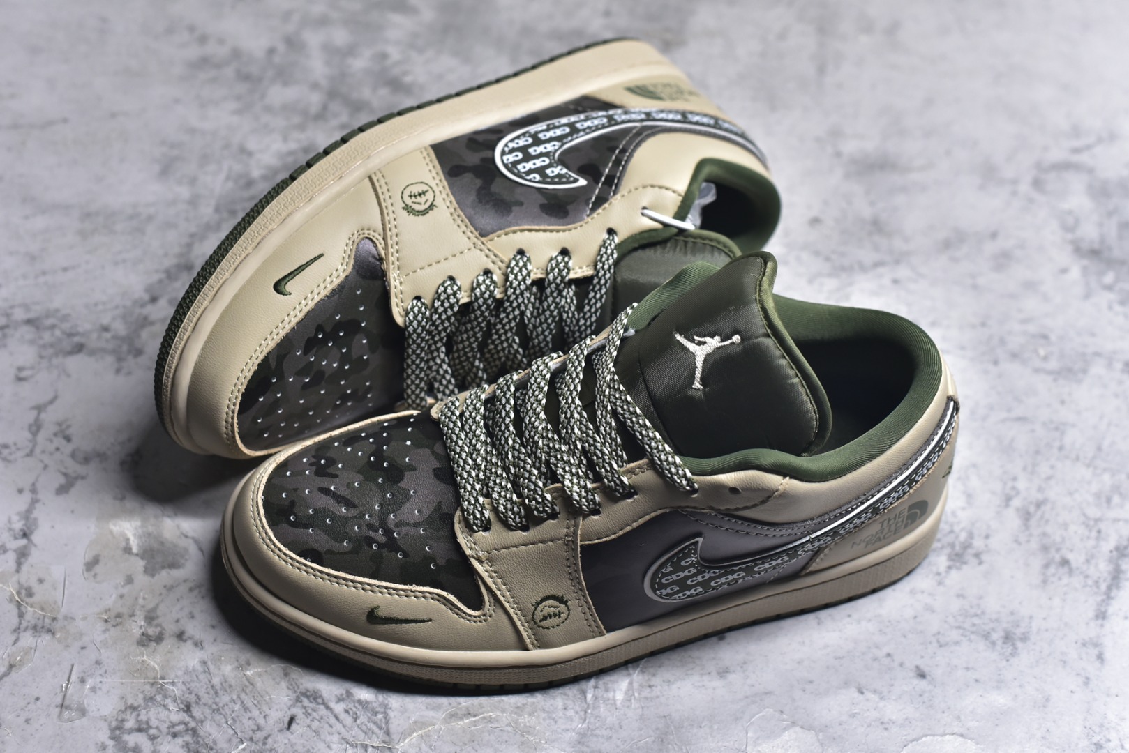 图片[7]-#Air Jordan 1 Low x 北面 x CDG 联名款｜野性与潮流的碰撞。当飞人图腾邂逅户外传奇，再融合先锋时尚的基因，这双Air Jordan 1 Low QG1988-017直接把跨界联名的质感拉满！浅卡其色鞋身搭配墨绿迷彩拼接，皮革与耐磨材质的碰撞，既有AJ1经典的复古轮廓，又注入了The North Face的户外硬核气质。鞋侧Swoosh满印CDG标识，后跟北面logo醒目点缀，三重品牌元素的融合毫不违和，每一处细节都透着潮流与机能的双重魅力。粗织鞋带、撞色包边的设计，让这双鞋不仅是穿搭利器，更暗藏户外探索的野性；低帮版型兼顾日常上脚的舒适与百搭，不管是街头潮搭还是轻户外造型，都能轻松hold住。这双集AJ的经典、北面的硬核、CDG的先锋于一体的联名款，是潮流玩家和户外爱好者都无法拒绝的收藏级单品！-选品中心