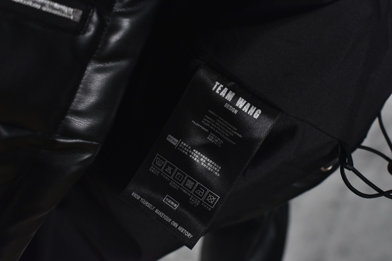图片[7]-#Team Wang 初代字母皮革立领羽绒服 -内里填充90白鸭绒，0码填充200克，1码填充220克，2码填充240克 -注：皮革材质的羽绒服洗涤需送至干洗店清洗，切记切记切记 一件好的单品应能融入多种生活场景，并易于打理以保持最佳状态，本次推出的羽绒服，可以看作是这一理念在实用主义单品上的投射，内填充物符合新国标90%白鸭绒标准，绒子含量高，蓬松度优异，能有效锁住空气，隔绝寒冷，由专业大厂加工，采用先进工艺严防跑绒。特别定制600克高克重袖子螺纹，确保多次洗涤后袖口仍保持版型，不变形、不松弛，主打利落的短款版型，旨在拉长身材比例，五金件的拉链、拉头、鸡眼等均注重质感，全部开模定制顺滑耐用，充绒量根据尺码递增确保不同体型穿着者都能获得合身的保暖体验，男女同款 尺码：0 1 2-选品中心