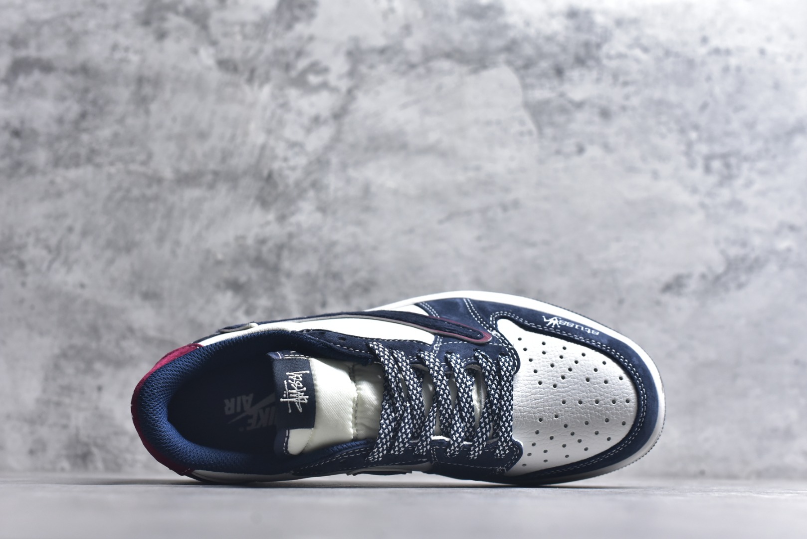 图片[4]-#街头联名，潮范拉满！当Air Jordan 1 Low的传奇鞋型邂逅Stüssy的街头灵魂，这双DZ5899-039联名款成为潮圈瞩目的重磅之作。 藏蓝与纯白的经典撞色打底，细腻的翻毛皮材质勾勒出鞋身的高级质感，酒红线条的点缀瞬间打破沉闷，让视觉层次更具张力。鞋侧的Stüssy字母印花、标志性的品牌吊坠，搭配鞋跟处的迷彩纹路与品牌标识，每一处细节都镌刻着街头潮牌的不羁个性，倒钩设计更是将潮流巧思拉满。经典的AJ1 Low鞋型保留了复古篮球的基因，又因Stüssy的注入焕发出浓郁的街头潮流气息。无论是搭配工装裤打造美式街头风，还是配牛仔裤诠释休闲潮范，这双鞋都能轻松成为造型核心，让你在潮搭中轻松脱颖而出。 尺码：36-45-选品中心