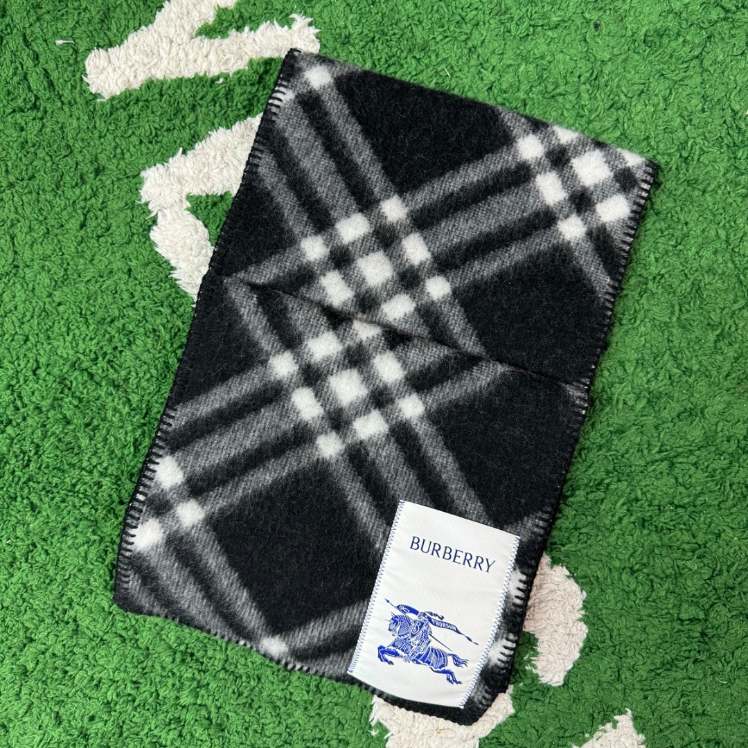 #Burberry/博柏利 黑格纹围巾 -正确细节，手工穿线包边 采用100%澳洲绵羊毛，确保了围巾的柔软亲肤和出色的保暖性，触感细腻不扎人，独特编织与包边，最大的特色在于粗线编织格工艺的一体式包边，这不仅是对经典格纹的另一种完美呈现，也体现了精湛的工艺，围巾握在手中能感受到如云朵般的空气绵绵感，这种蓬松柔软的体验得益于复杂的后整工艺，采用AB双面设计，正反面均为Burberry经典格纹，并通过独特的配色与工艺，作为男女同款的设计，它非常适合作为情侣搭配，能够轻松融入各种穿搭风格，无论是休闲还是正式场合都能驾驭 尺码：180×30cm-选品中心