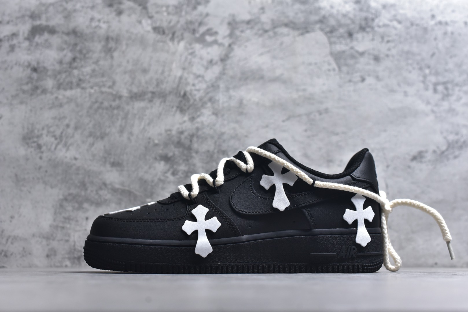 #“黑耀十字”✨订制空军一号板鞋 该定制版球鞋选用原鞋款为Nike Air Force 1\'07空军一号，鞋身通体为黑色哑光质感，搭配多处Chrome Hearts标志性的白色十字皮标，是整双鞋的视觉核心，极具辨识度。搭配粗款米白色麻绳鞋带，增加了复古与街头感；鞋舌处还加入克罗心风格的金属挂饰，进一步强化联名定制的细节质感。 货号：CW2288-001 尺码： 36 36.5 37.5 38 38.5 39 40 40.5 41 42 42.5 43 44 44.5 45-选品中心