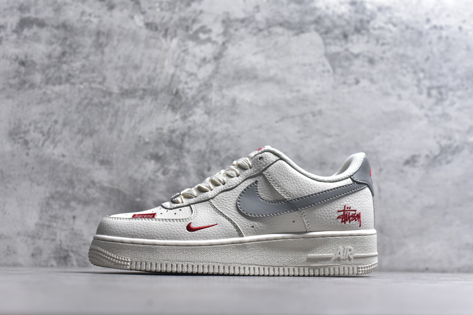 #潮圈顶流联名炸场！AF1联手Stussy+Supreme玩转出圈设计，白灰红撞色瞬间抓住眼球，荔枝纹皮质质感拉满，鞋侧Stussy手写logo和鞋头Supreme小标，把联名身份焊死在细节里。经典Air气垫加持，踩屎感十足还兼顾支撑性，日常出街或搭配潮装都能秒变焦点，妥妥的潮人必备款！ 货号：MM3399-803 尺码：36 36.5 37.5 38 38.5 39 40 40.5 41 42 42.5 43 44 44.5 45-选品中心