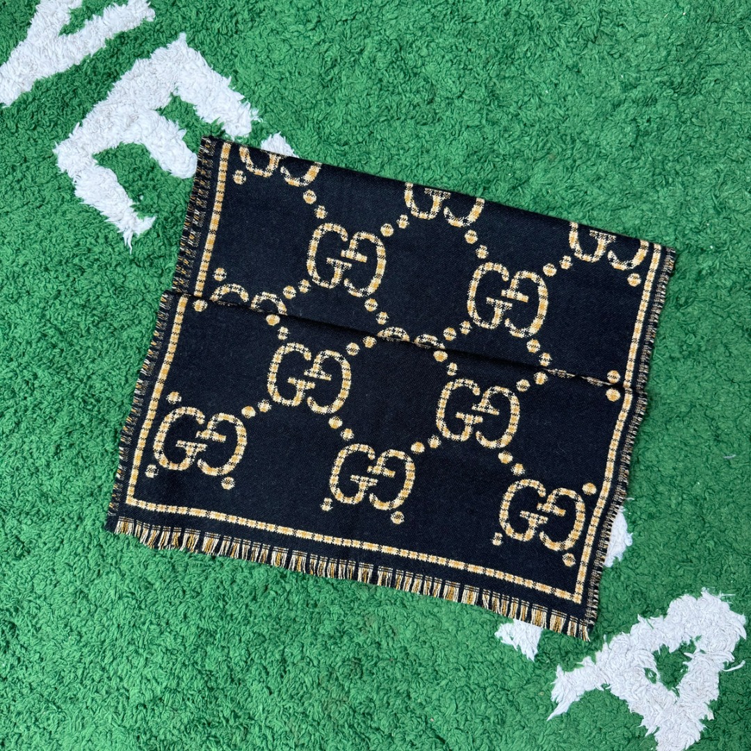 #Gucci/古驰 黑金双G流苏围巾 围巾采用双面设计，一面饰有经典的GG老花图案，另一面则是简约素色，相当于一条围巾的价格，获得两种不同的穿搭风格，细节上，烫金元素或细碎金线的加入，打破了秋冬的沉闷感，在不经意间透露出低调的高级感，超大尺寸让它远超普通围巾的功能，你可以轻松地将其作为披肩搭配，增添大气场，也可以绕颈一两次，打造慵懒而精致的层次感。由于其足够宽大厚实，在微凉天气里完全可以作为一件时尚的小外套使用，真正实现“凹造型与保暖”兼得，围巾采用100%新剪羊毛，材质本身具有优异的保暖性，经过巴素兰工艺处理，触感软糯亲肤，避免了普通羊毛的扎刺感 尺码：180×49cm，流苏2cm-选品中心