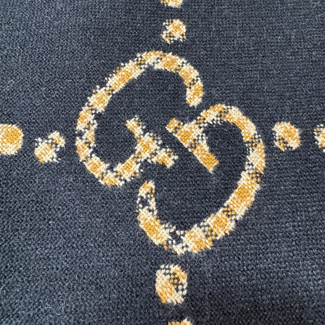 图片[3]-#Gucci/古驰 黑金双G流苏围巾 围巾采用双面设计，一面饰有经典的GG老花图案，另一面则是简约素色，相当于一条围巾的价格，获得两种不同的穿搭风格，细节上，烫金元素或细碎金线的加入，打破了秋冬的沉闷感，在不经意间透露出低调的高级感，超大尺寸让它远超普通围巾的功能，你可以轻松地将其作为披肩搭配，增添大气场，也可以绕颈一两次，打造慵懒而精致的层次感。由于其足够宽大厚实，在微凉天气里完全可以作为一件时尚的小外套使用，真正实现“凹造型与保暖”兼得，围巾采用100%新剪羊毛，材质本身具有优异的保暖性，经过巴素兰工艺处理，触感软糯亲肤，避免了普通羊毛的扎刺感 尺码：180×49cm，流苏2cm-选品中心