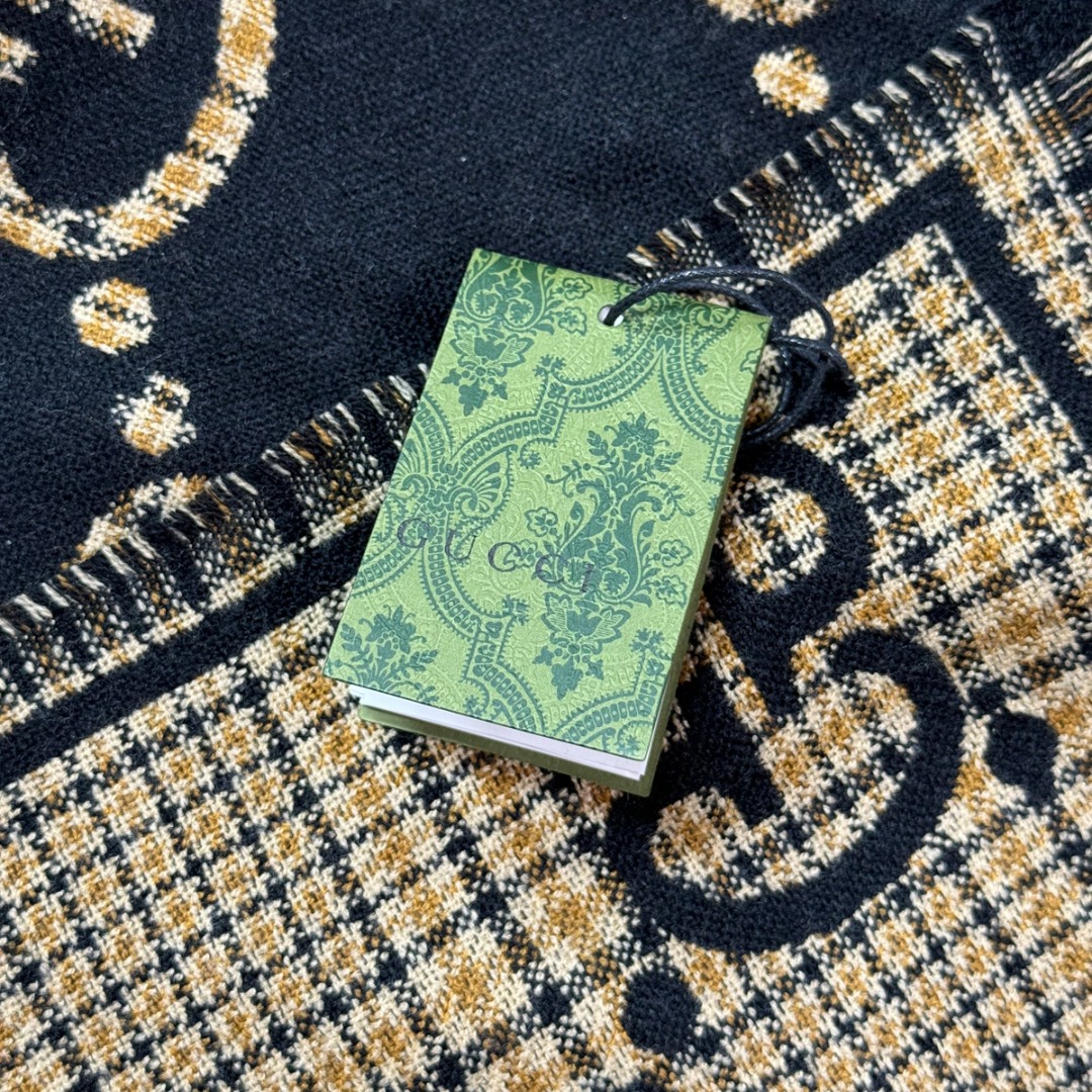 图片[7]-#Gucci/古驰 黑金双G流苏围巾 围巾采用双面设计，一面饰有经典的GG老花图案，另一面则是简约素色，相当于一条围巾的价格，获得两种不同的穿搭风格，细节上，烫金元素或细碎金线的加入，打破了秋冬的沉闷感，在不经意间透露出低调的高级感，超大尺寸让它远超普通围巾的功能，你可以轻松地将其作为披肩搭配，增添大气场，也可以绕颈一两次，打造慵懒而精致的层次感。由于其足够宽大厚实，在微凉天气里完全可以作为一件时尚的小外套使用，真正实现“凹造型与保暖”兼得，围巾采用100%新剪羊毛，材质本身具有优异的保暖性，经过巴素兰工艺处理，触感软糯亲肤，避免了普通羊毛的扎刺感 尺码：180×49cm，流苏2cm-选品中心