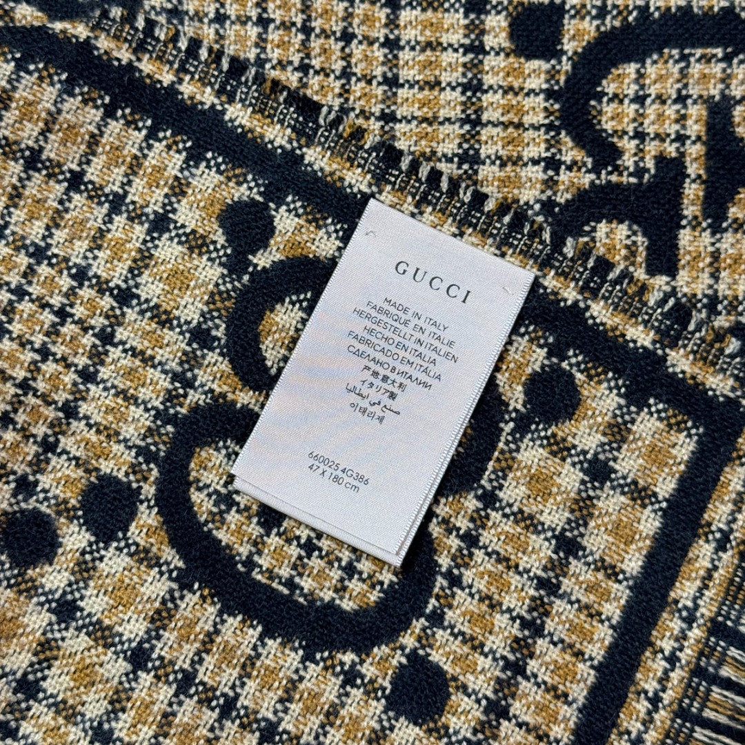 图片[8]-#Gucci/古驰 黑金双G流苏围巾 围巾采用双面设计，一面饰有经典的GG老花图案，另一面则是简约素色，相当于一条围巾的价格，获得两种不同的穿搭风格，细节上，烫金元素或细碎金线的加入，打破了秋冬的沉闷感，在不经意间透露出低调的高级感，超大尺寸让它远超普通围巾的功能，你可以轻松地将其作为披肩搭配，增添大气场，也可以绕颈一两次，打造慵懒而精致的层次感。由于其足够宽大厚实，在微凉天气里完全可以作为一件时尚的小外套使用，真正实现“凹造型与保暖”兼得，围巾采用100%新剪羊毛，材质本身具有优异的保暖性，经过巴素兰工艺处理，触感软糯亲肤，避免了普通羊毛的扎刺感 尺码：180×49cm，流苏2cm-选品中心