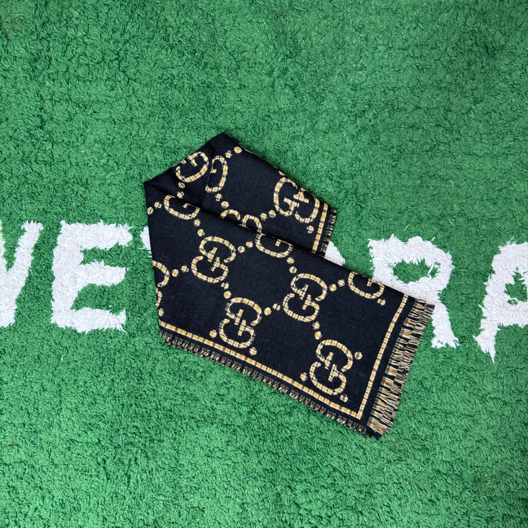 图片[2]-#Gucci/古驰 黑金双G流苏围巾 围巾采用双面设计，一面饰有经典的GG老花图案，另一面则是简约素色，相当于一条围巾的价格，获得两种不同的穿搭风格，细节上，烫金元素或细碎金线的加入，打破了秋冬的沉闷感，在不经意间透露出低调的高级感，超大尺寸让它远超普通围巾的功能，你可以轻松地将其作为披肩搭配，增添大气场，也可以绕颈一两次，打造慵懒而精致的层次感。由于其足够宽大厚实，在微凉天气里完全可以作为一件时尚的小外套使用，真正实现“凹造型与保暖”兼得，围巾采用100%新剪羊毛，材质本身具有优异的保暖性，经过巴素兰工艺处理，触感软糯亲肤，避免了普通羊毛的扎刺感 尺码：180×49cm，流苏2cm-选品中心