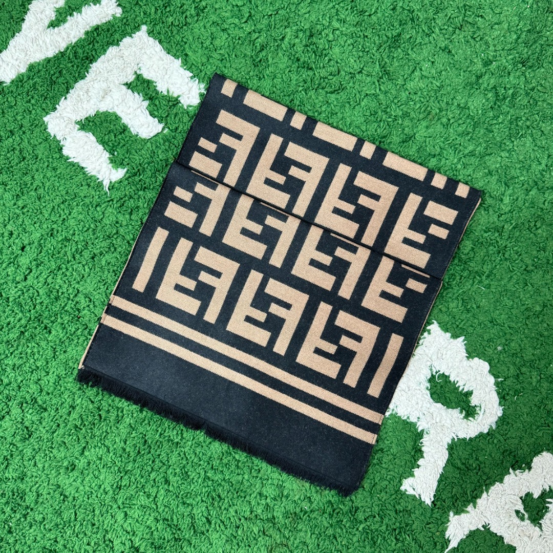 #Fendi/芬迪 横杠FF老花流苏围巾 严格采用原版规格面料，95%优质羊毛+5%桑蚕丝混纺，得益于精梳工艺与高密度织法，围巾手感软糯亲肤，触感细腻不扎人，同时保证了面料的挺括度和垂坠感，实现了柔软与有型的完美平衡，双面可用设计，一面是深邃神秘的黑色底FF老花，另一面是温暖经典的驼色底FF老花，一条围巾相当于两种风格，随心切换，从水洗标、内标到吊牌、编号，均为一致，标签字体、缝线工艺等细节均严格对标，超大尺寸既可作围巾，也可当披肩，FF老花图案是品牌最具辨识度的视觉符号，自带高级气场，能瞬间提升整体穿搭的时尚感，让日常造型“UpUp” 尺码：187×38cm，流苏1.5cm-选品中心