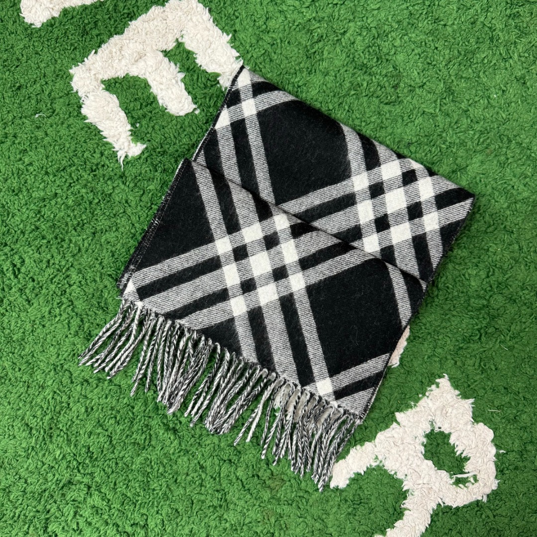 #Burberry/博柏利 黑格纹流苏围巾 -正确细节，手工穿线包边 采用100%澳洲绵羊毛，确保了围巾的柔软亲肤和出色的保暖性，触感细腻不扎人，独特编织与包边，最大的特色在于粗线编织格工艺的一体式包边，这不仅是对经典格纹的另一种完美呈现，也体现了精湛的工艺，围巾握在手中能感受到如云朵般的空气绵绵感，这种蓬松柔软的体验得益于复杂的后整工艺，采用AB双面设计，正反面均为Burberry经典格纹，并通过独特的配色与工艺，作为男女同款的设计，它非常适合作为情侣搭配，能够轻松融入各种穿搭风格，无论是休闲还是正式场合都能驾驭 尺码：182×30cm，流苏10cm-选品中心