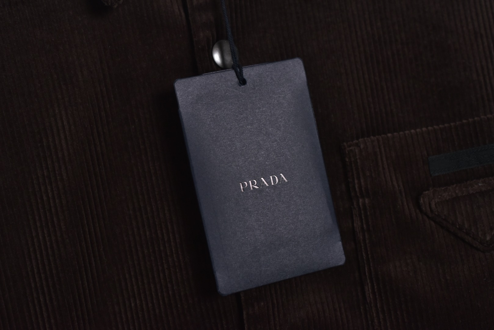 图片[4]-#PRD灯芯绒贴布棉服 深棕色 乌木色款为100%棉 填充层为55%再生聚酯纤维+45%聚酯纤维 采用Prada 2025秋冬新配方 将传统灯芯绒克重从380g/㎡降至260g/㎡ 兼顾透气性与挺括度 经纱选用28tex×2（21/2英支）股线 纬纱为28tex（21英支）单纱 符合高端灯芯绒纱线规格 成品克重260g/㎡ 属于轻盈型灯芯绒 绒条细腻且回弹无褶 整体采用压胶工艺替代传统平车踩线，接缝处密封性好，且减少线迹磨损风险 面料经过预洗水+软整理 绒面手感柔软且无浮色 色牢度达ISO 105标准4级以上 尺码：XS S M L-选品中心