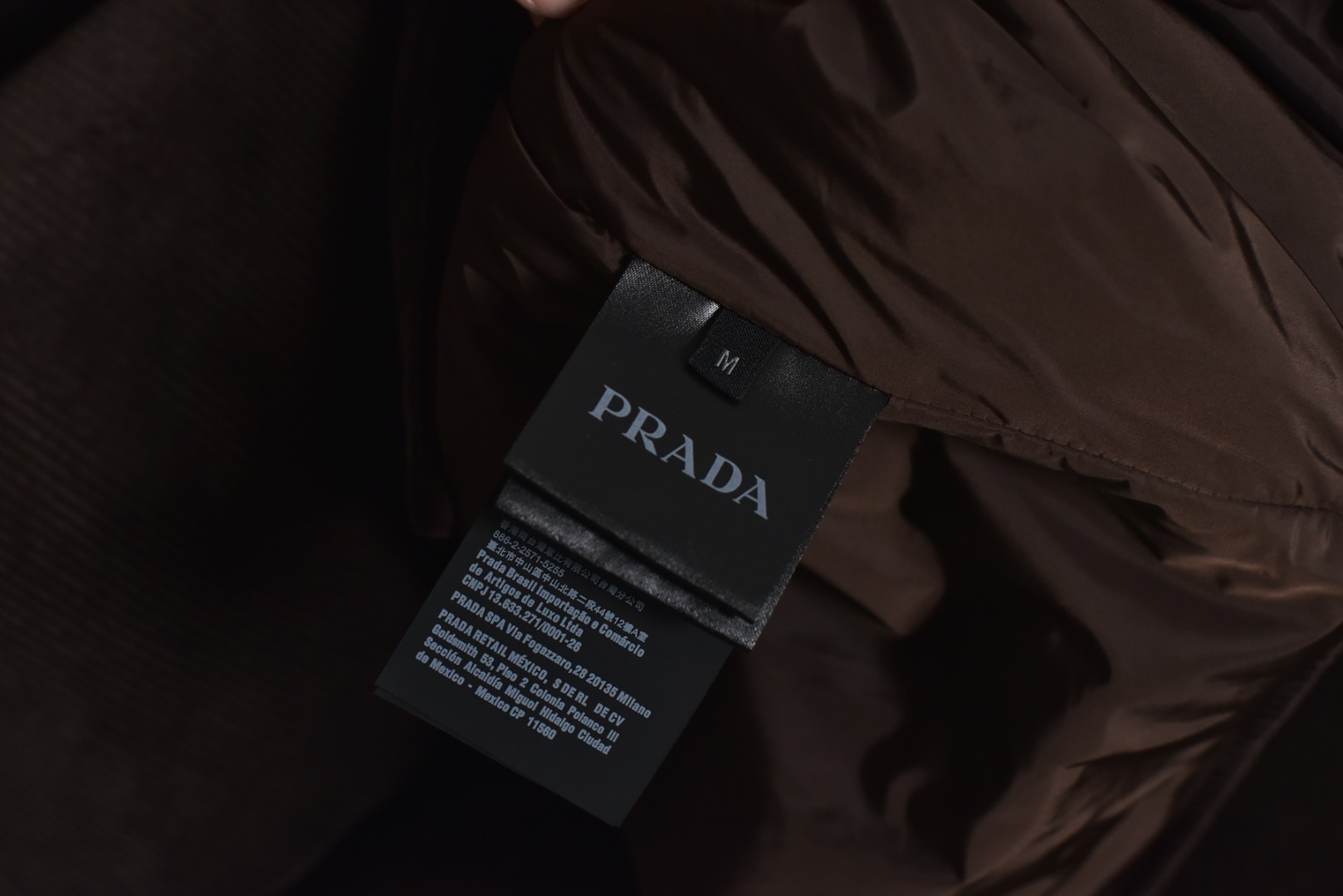 图片[7]-#PRD灯芯绒贴布棉服 深棕色 乌木色款为100%棉 填充层为55%再生聚酯纤维+45%聚酯纤维 采用Prada 2025秋冬新配方 将传统灯芯绒克重从380g/㎡降至260g/㎡ 兼顾透气性与挺括度 经纱选用28tex×2（21/2英支）股线 纬纱为28tex（21英支）单纱 符合高端灯芯绒纱线规格 成品克重260g/㎡ 属于轻盈型灯芯绒 绒条细腻且回弹无褶 整体采用压胶工艺替代传统平车踩线，接缝处密封性好，且减少线迹磨损风险 面料经过预洗水+软整理 绒面手感柔软且无浮色 色牢度达ISO 105标准4级以上 尺码：XS S M L-选品中心