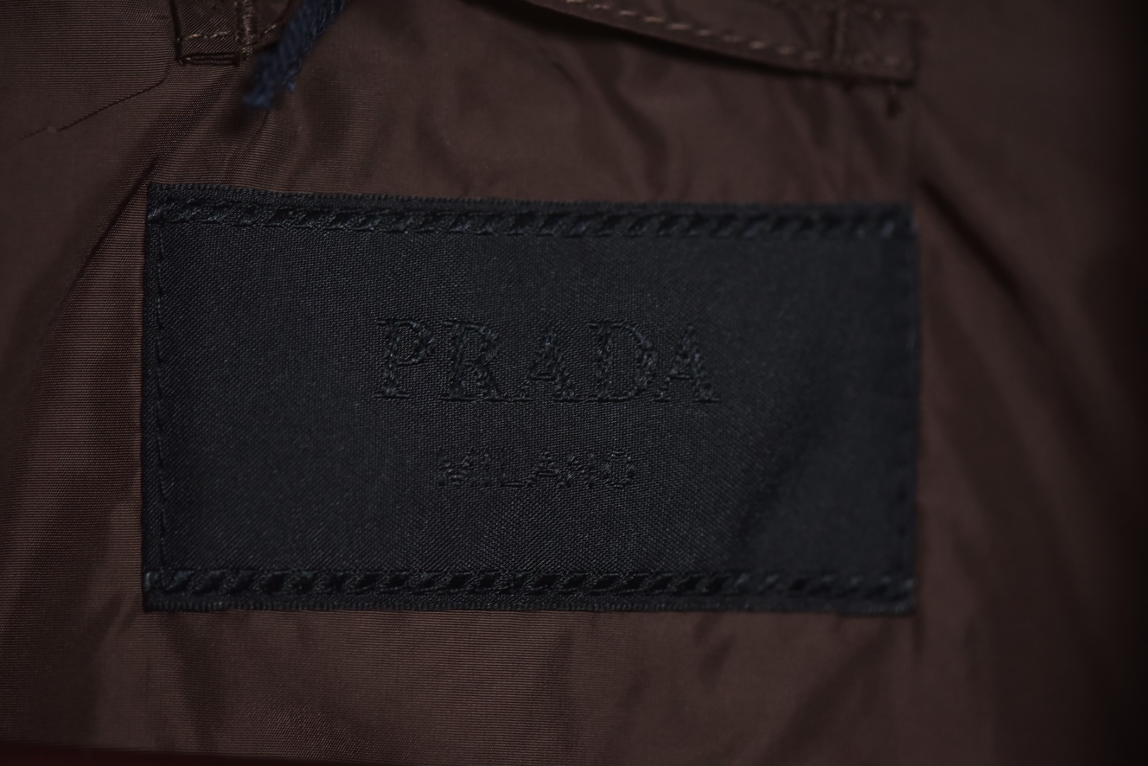图片[8]-#PRD灯芯绒贴布棉服 深棕色 乌木色款为100%棉 填充层为55%再生聚酯纤维+45%聚酯纤维 采用Prada 2025秋冬新配方 将传统灯芯绒克重从380g/㎡降至260g/㎡ 兼顾透气性与挺括度 经纱选用28tex×2（21/2英支）股线 纬纱为28tex（21英支）单纱 符合高端灯芯绒纱线规格 成品克重260g/㎡ 属于轻盈型灯芯绒 绒条细腻且回弹无褶 整体采用压胶工艺替代传统平车踩线，接缝处密封性好，且减少线迹磨损风险 面料经过预洗水+软整理 绒面手感柔软且无浮色 色牢度达ISO 105标准4级以上 尺码：XS S M L-选品中心