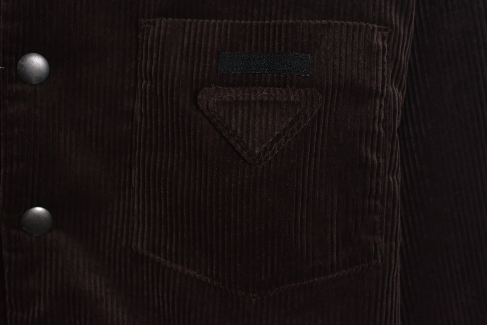 图片[9]-#PRD灯芯绒贴布棉服 深棕色 乌木色款为100%棉 填充层为55%再生聚酯纤维+45%聚酯纤维 采用Prada 2025秋冬新配方 将传统灯芯绒克重从380g/㎡降至260g/㎡ 兼顾透气性与挺括度 经纱选用28tex×2（21/2英支）股线 纬纱为28tex（21英支）单纱 符合高端灯芯绒纱线规格 成品克重260g/㎡ 属于轻盈型灯芯绒 绒条细腻且回弹无褶 整体采用压胶工艺替代传统平车踩线，接缝处密封性好，且减少线迹磨损风险 面料经过预洗水+软整理 绒面手感柔软且无浮色 色牢度达ISO 105标准4级以上 尺码：XS S M L-选品中心