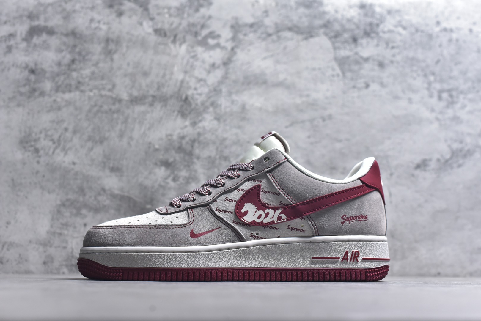#马年联名重磅登场 AIR FORCE 1 灰红白三色拼接打造复古氛围，满印Supreme Logo强化联名辨识度，侧身“2026”与马形图案点明马年主题，金属挂饰为鞋身注入精致感。经典Air Force 1鞋型搭载Air缓震科技，兼顾潮流属性与穿着体验，是新年收藏、穿搭的双选好物。 货号：JP2026-132 尺码：36 36.5 37.5 38 38.5 39 40 40.5 41 42 42.5 43 44 44.5 45-选品中心
