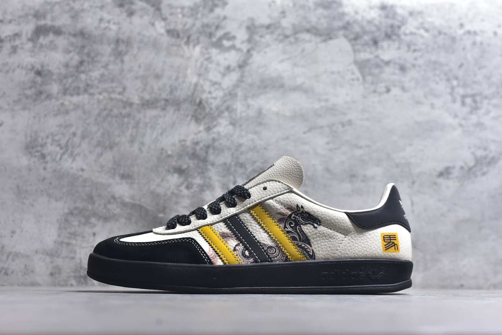 #马年新款海外定制限量发售 Adidas Originals GAZELLE INDOOR“马年联名限定-鎏金黑”专为 2026 丙午马年打造的国风限定德训鞋，将水墨奔马与鎏金纹样融入复古鞋型，鞋身满印墨韵奔马 + 卷草纹，搭配鞋侧 “马” 字印章，白荔枝纹皮革碰撞黑金黄条纹，黑色翻毛皮鞋头 + 编织鞋带，层次丰富不单调，复古感与高级感兼备！ 货号：LX0903 尺码：36 36.5 37.5 38 38.5 39 40 40.5 41 42 42.5 43 44 44.5 45-选品中心