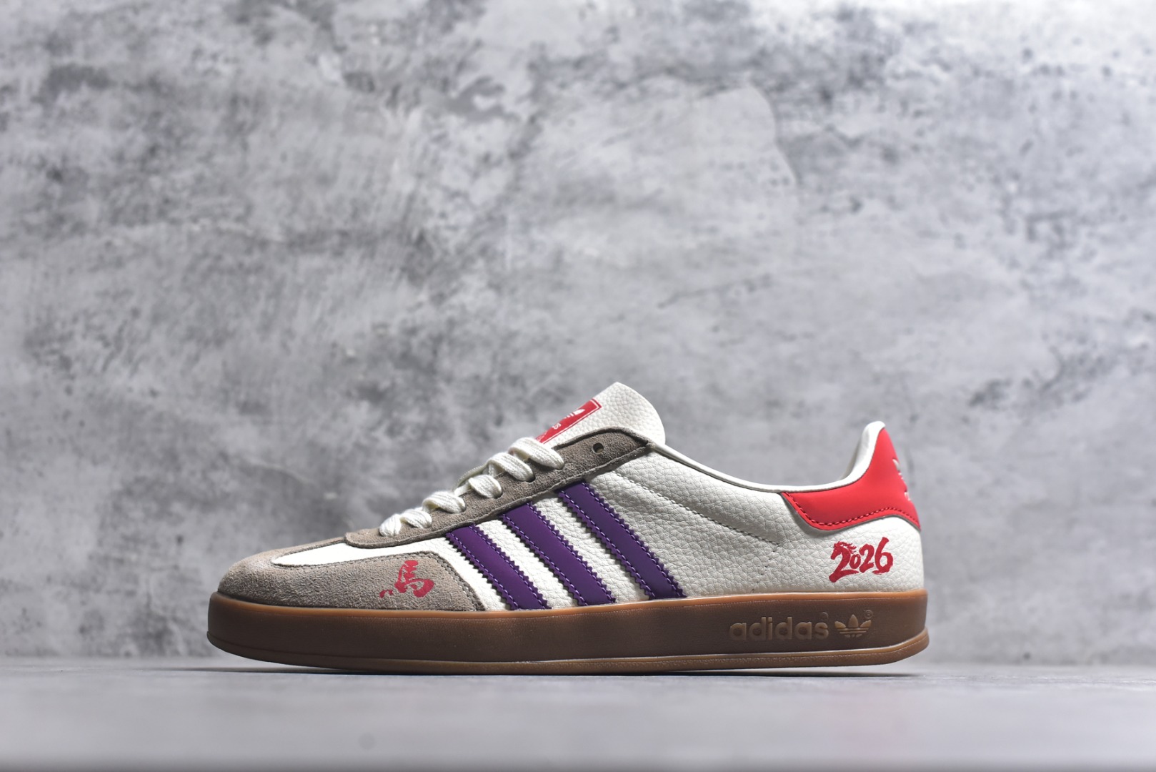 #马年新款海外定制限量发售 Adidas Originals GAZELLE INDOOR“马年联名限定-紫韵红运”专为 2026 丙午马年打造的限定德训鞋，以温柔紫调碰撞鲜活红运，鞋尾 “2026” 奔马印花灵动鲜活，鞋头 “马” 字书法笔触洒脱，米白荔枝纹皮革搭配紫色条纹 + 卡其翻毛鞋头，红色鞋尾点亮视觉，绒面鞋面柔软亲肤，橡胶防滑大底稳当贴脚，既是街头复古单品，也是新年氛围感利器。 货号：ZH2597 尺码：36 36.5 37.5 38 38.5 39 40 40.5 41 42 42.5 43 44 44.5 45-选品中心