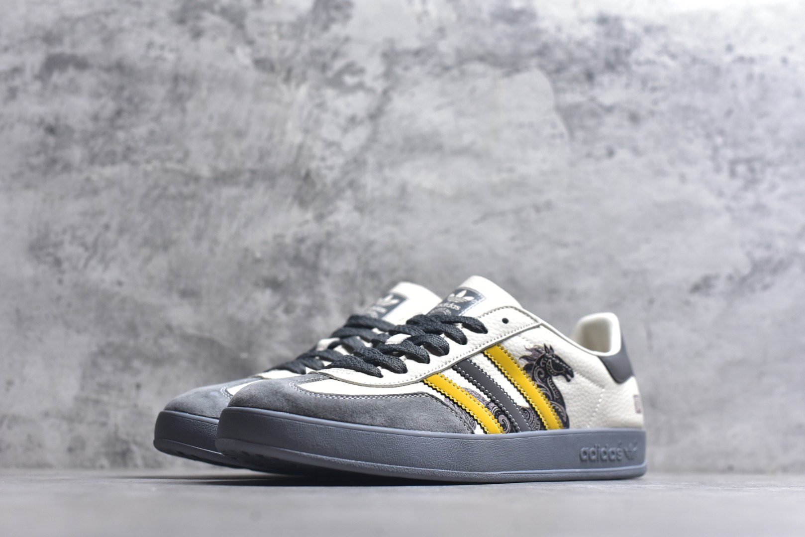 图片[2]-#马年新款海外定制限量发售 Adidas Originals GAZELLE INDOOR“马年联名限定-图腾腰果花”专为 2026 丙午马年打造的限定德训鞋，延续 adidas 经典板鞋版型，软弹中底兼顾支撑性与舒适度，经典三道杠升级为黄黑撞色，在米白帆布与灰色翻毛皮的基底上更具视觉冲击力，鞋身侧部的骏马纹样线条细腻，绒面鞋面柔软亲肤，橡胶防滑大底稳当贴脚 货号：JJ2605 尺码：36 36.5 37.5 38 38.5 39 40 40.5 41 42 42.5 43 44 44.5 45-选品中心