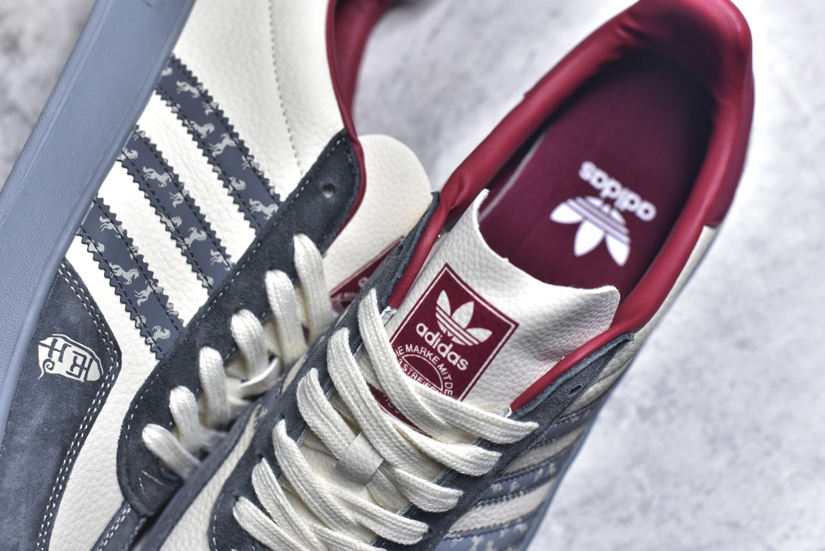 图片[9]-#马年新款海外定制限量发售 Adidas Originals GAZELLE INDOOR“马年联名限定-雅灰”专为 2026 丙午马年打造的限定德训鞋，延续 adidas 经典板鞋版型，经典三道杠采用黑底白纹织带，表面满印骏马剪影暗纹，鞋身主体为米白帆布，搭配做旧灰翻毛皮鞋头、酒红鞋尾及同色系橡胶外底，低饱和配色自带高级氛围感，荔枝皮鞋面柔软亲肤，橡胶防滑大底稳当贴脚 货号：ZH2603 尺码：36 36.5 37.5 38 38.5 39 40 40.5 41 42 42.5 43 44 44.5 45-选品中心