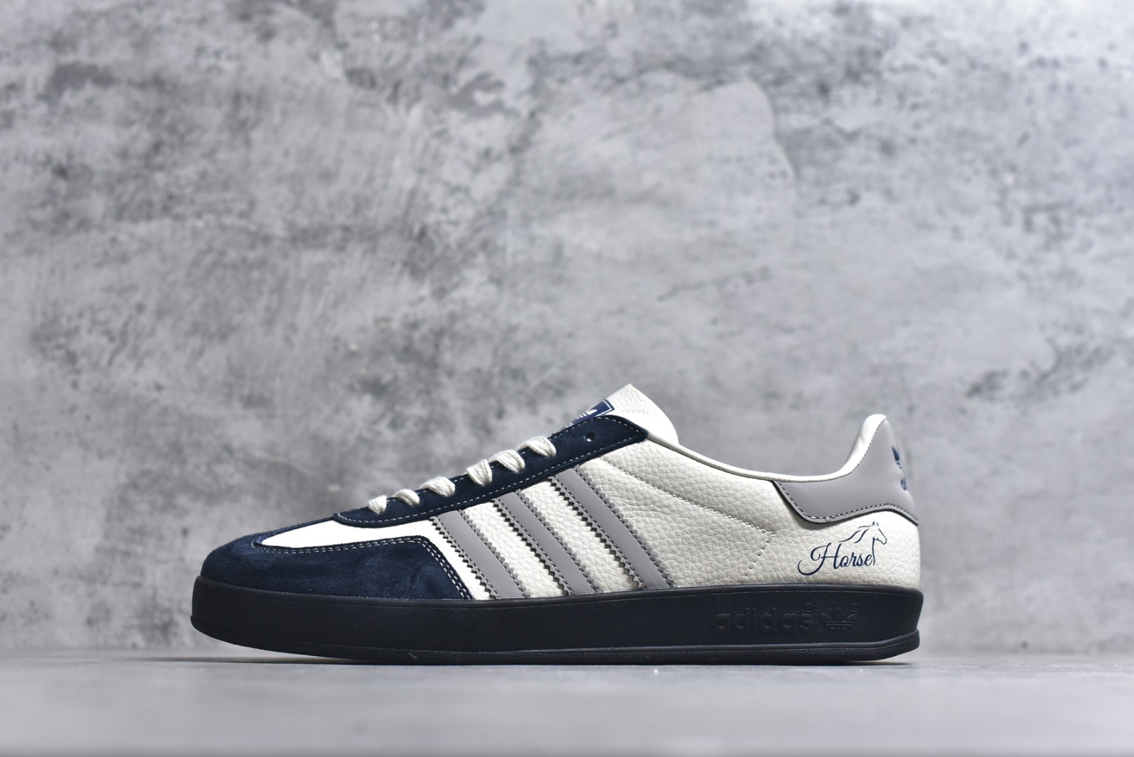 #马年新款海外定制限量发售 Adidas Originals GAZELLE INDOOR“马年联名限定-雅灰”专为 2026 丙午马年打造的限定德训鞋，延续 adidas 经典板鞋版型，鞋尾印有深蓝色手写体 Horse字样与骏马剪影，笔触随性自然，搭配藏青翻毛皮鞋头、浅灰三道杠及全黑橡胶外底，荔枝皮鞋面柔软亲肤，橡胶防滑大底稳当贴脚 货号：ZH2602 尺码：36 36.5 37.5 38 38.5 39 40 40.5 41 42 42.5 43 44 44.5 45-选品中心