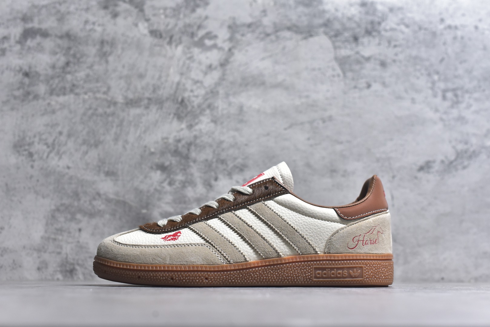 #马年新款海外定制限量发售 Adidas Originals GAZELLE INDOOR“马年联名限定-复古棕”专为 2026 丙午马年打造的限定德训鞋，延续 adidas 经典板鞋版型，鞋尾印有红色手写体 Horse 字样与骏马剪影，鞋头点缀同款迷你刺绣，配深棕翻毛皮鞋头、浅棕三道杠及深棕鞋尾，标志性生胶外底加持，荔枝皮鞋面柔软亲肤，橡胶防滑大底稳当贴脚 货号：JJ2620 尺码：36 36.5 37.5 38 38.5 39 40 40.5 41 42 42.5 43 44 44.5 45-选品中心