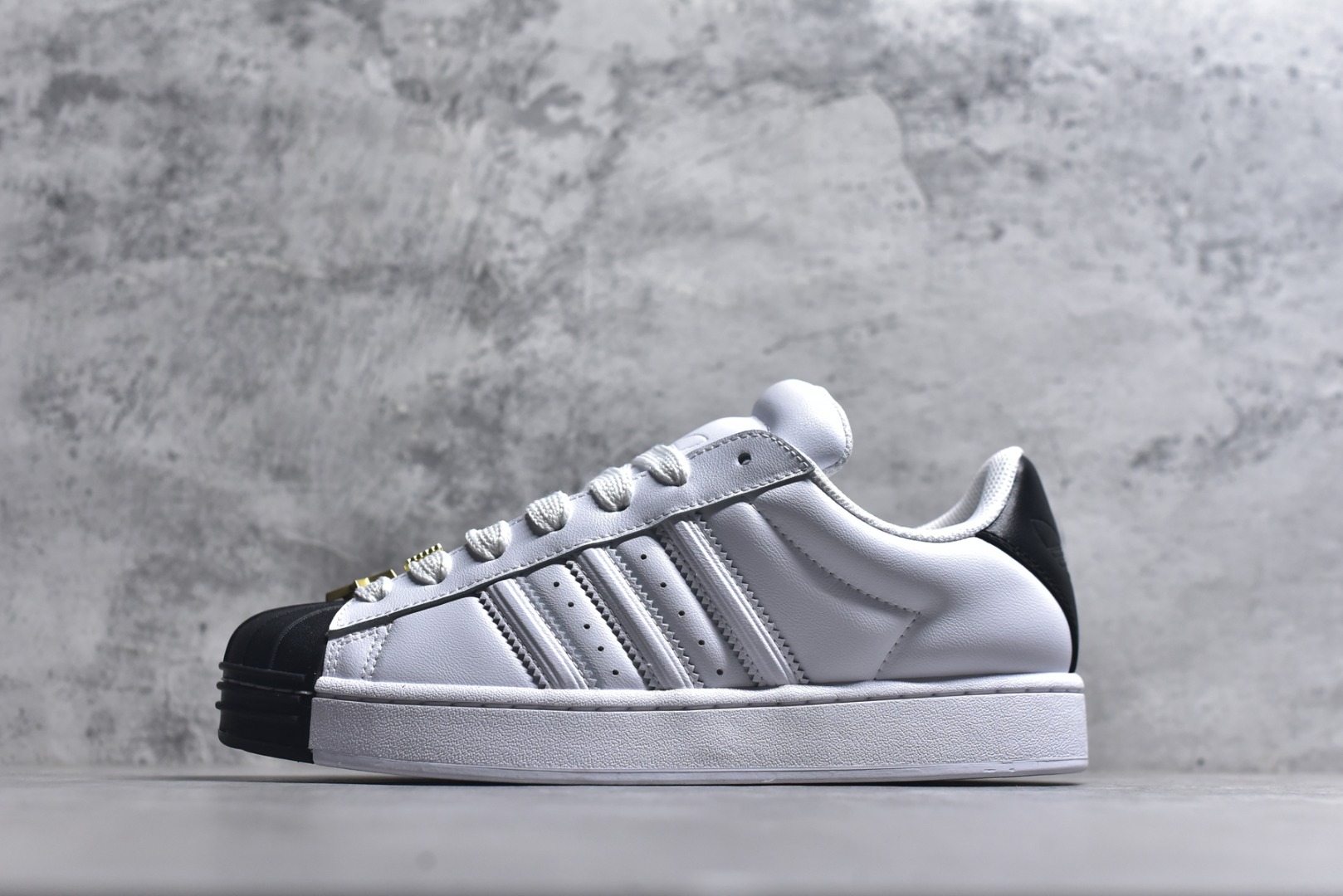 #AF Originals Superstar 2 贝壳头二代舒适百搭 板鞋面包鞋 IH6679 贝壳头诞生于1969年是第一双将全皮面鞋 身与橡胶鞋头结合在一起的低帮篮球鞋 Superstar最开始 是作为高帮篮球鞋Pro Model的低帮版本而出现的 但因为其独特和醒目的橡胶鞋头造型而让大家熟知 被大家形象地称为\