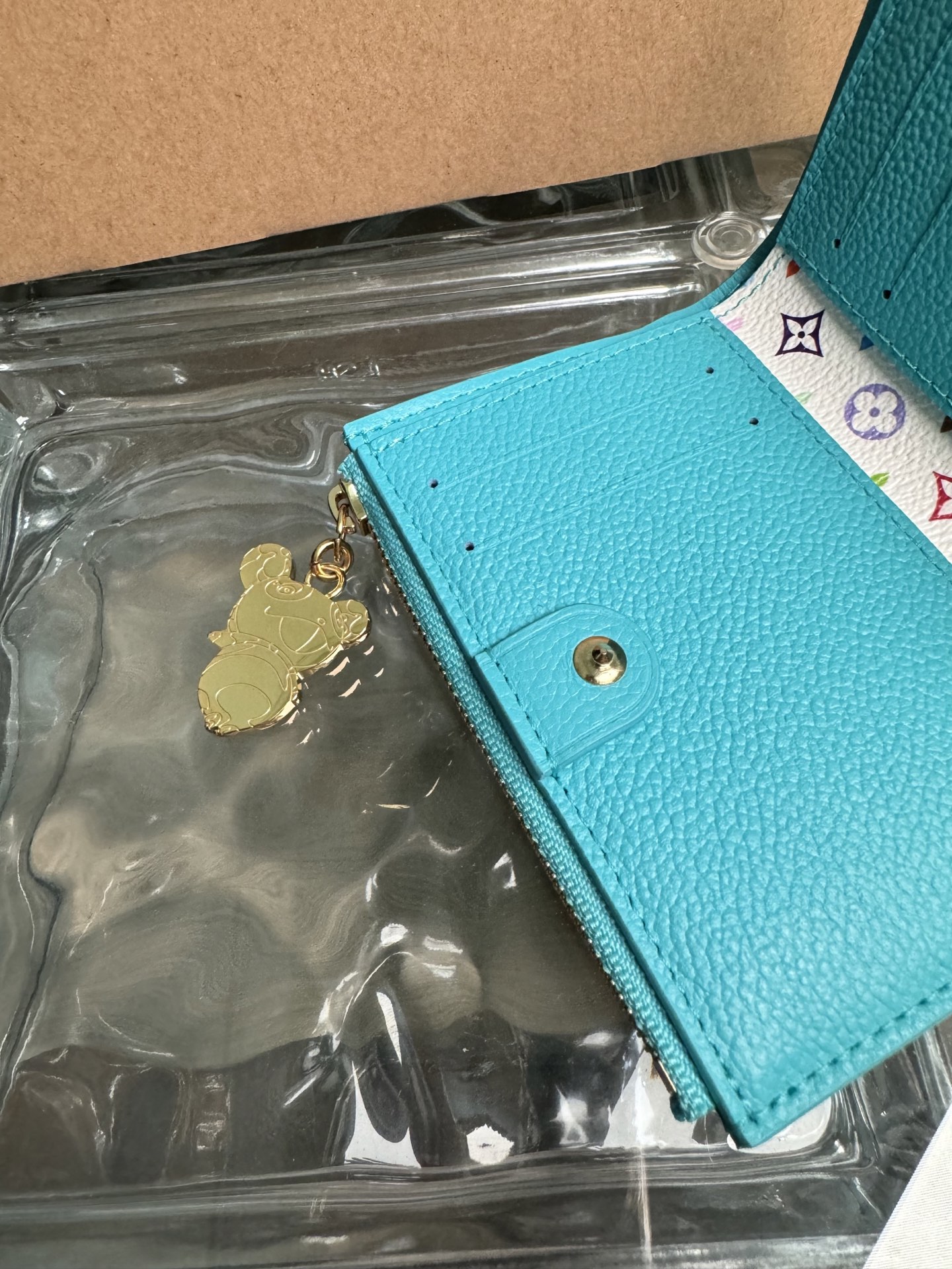 p360。M14089【官方全钢芯片版163c01】
丽莎钱包是日常必需品，采用实用的紧凑设计，配有紧固的硬币口袋、纸币隔层和多个卡槽。它由路易威登优雅的Monogram Empreinte皮革制成，采用路易威登x村上隆系列中清新的季节性色调，内部还点缀着多彩的Monogram图案。金色熊猫形状的拉链头为拉链增添了一抹活力。9x11.5x1.5cm 