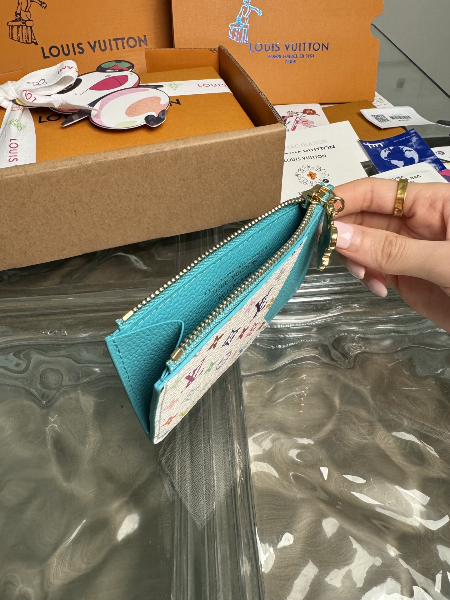 p320。M14171【官方全钢芯片版163c01】
作为跨类别路易威登x村上隆系列的一部分，Romy卡片夹既实用又充满趣味，采用清新色彩，灵感源自这位日本艺术家惯用的彩虹调色板。它巧妙地在整个 Monogram Empreinte皮革上签名，而平口袋则用多色Monogram涂层帆布鲜艳地突出显示。硬币口袋用金色拉链固定，拉链边缘装饰有熊猫形状的拉头，作为最后的季节性点缀。12x8x0.8cm 