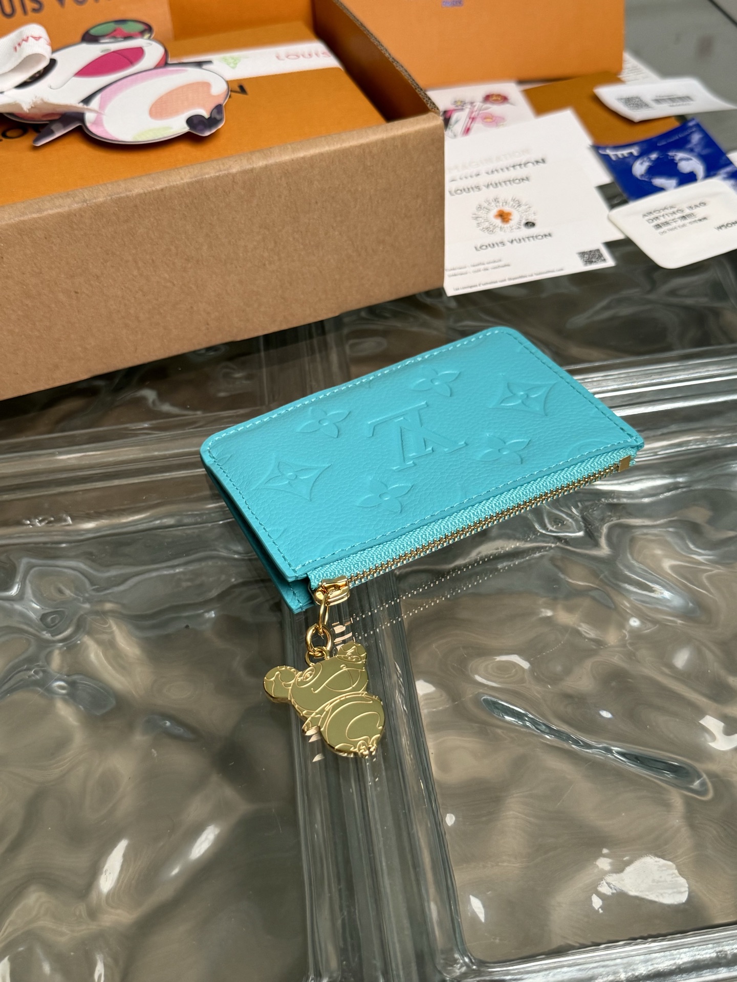 p320。M14171【官方全钢芯片版163c01】
作为跨类别路易威登x村上隆系列的一部分，Romy卡片夹既实用又充满趣味，采用清新色彩，灵感源自这位日本艺术家惯用的彩虹调色板。它巧妙地在整个 Monogram Empreinte皮革上签名，而平口袋则用多色Monogram涂层帆布鲜艳地突出显示。硬币口袋用金色拉链固定，拉链边缘装饰有熊猫形状的拉头，作为最后的季节性点缀。12x8x0.8cm 