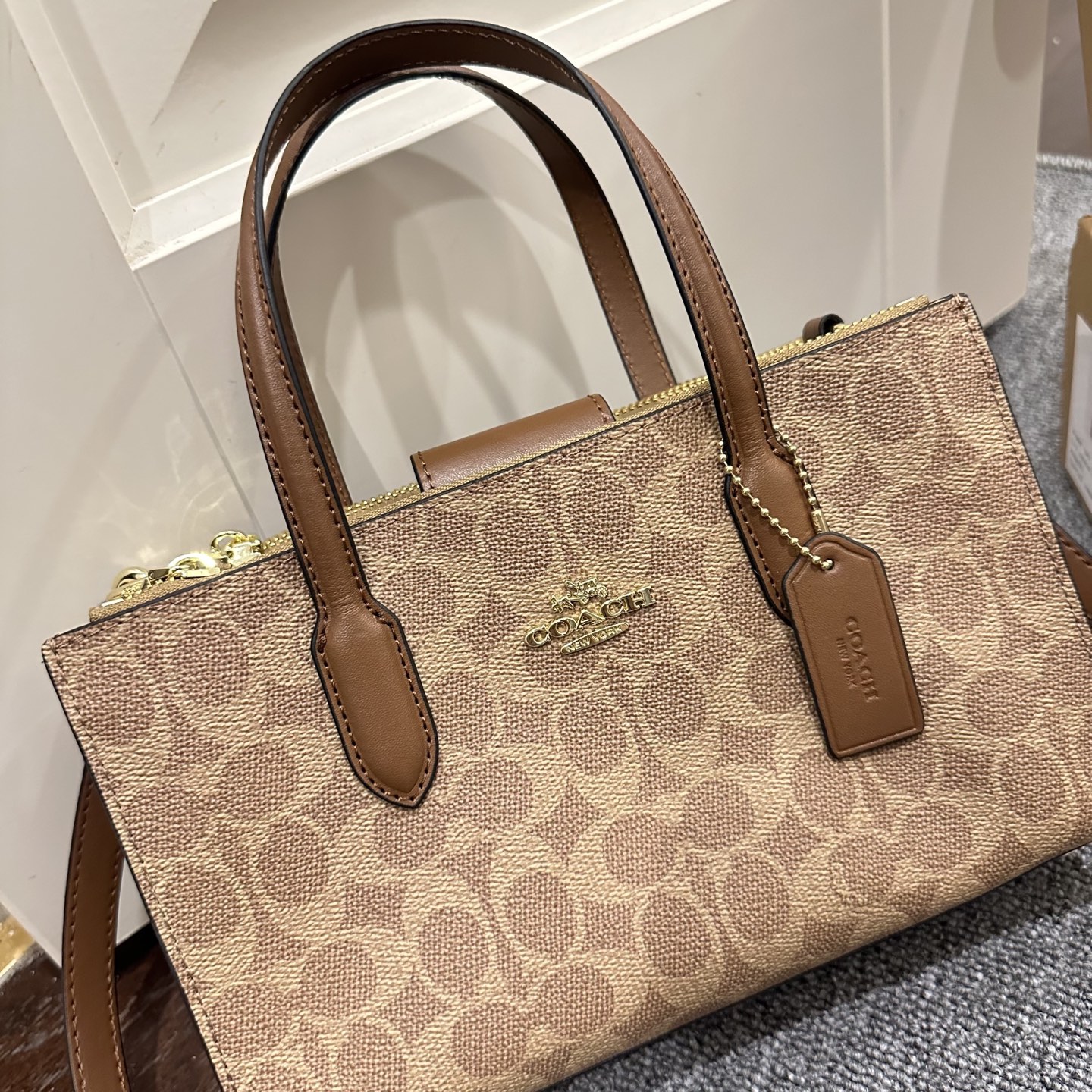 Caja de regalo. El nuevo tote pequeño de la serie Nina de Coach, material en relieve, con cremalleras en ambos lados pa…