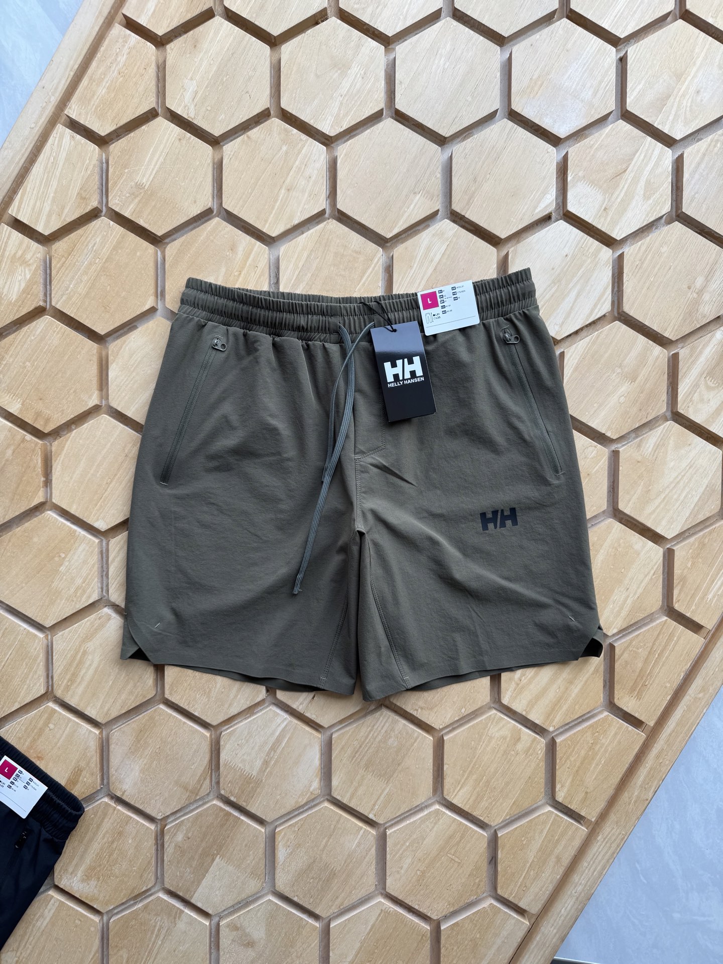 P135 
想要在户外尽情撒野，又不想被闷热和汗水困扰？海丽汉森这款弹力速干户外休闲短裤，绝对是你的夏日救星！

它采用高品质弹力面料，拉伸自如，无论是徒步登山，还是跑步骑行，都能毫无束缚地自由舒展。速干性能更是一绝，即使大汗淋漓，也能迅速干爽，保持全天舒适。

两边压胶拉链口袋，不仅防水，还能安心存放手机、钱包等小物件，再也不用担心物品丢失或被雨水打湿。简约北欧风设计，融合时尚与实用，无论是户外探险，还是日常出街，都能轻松驾驭，彰显独特品味。

选海丽汉森弹力速干短裤，开启清爽、自由的户外之旅 ，这个夏天，和汗水与闷热说再见！
颜色 黑色 绿色
尺码M-3xL