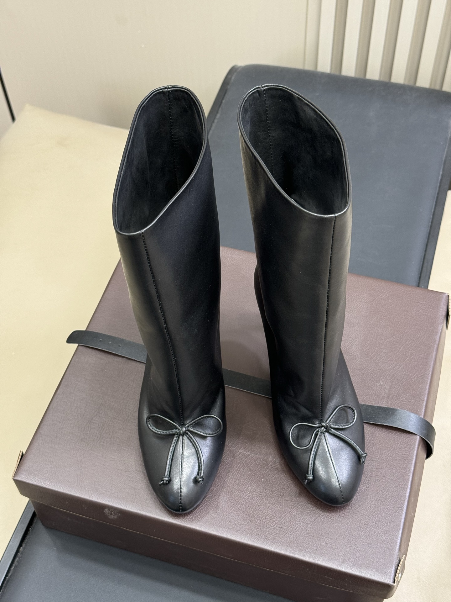 
ALAIA｜易梦玲同款高跟短靴
该款黑色小牛皮高跟短靴，正面点缀装饰蝴蝶结，搭配90毫米鞋跟与22厘米