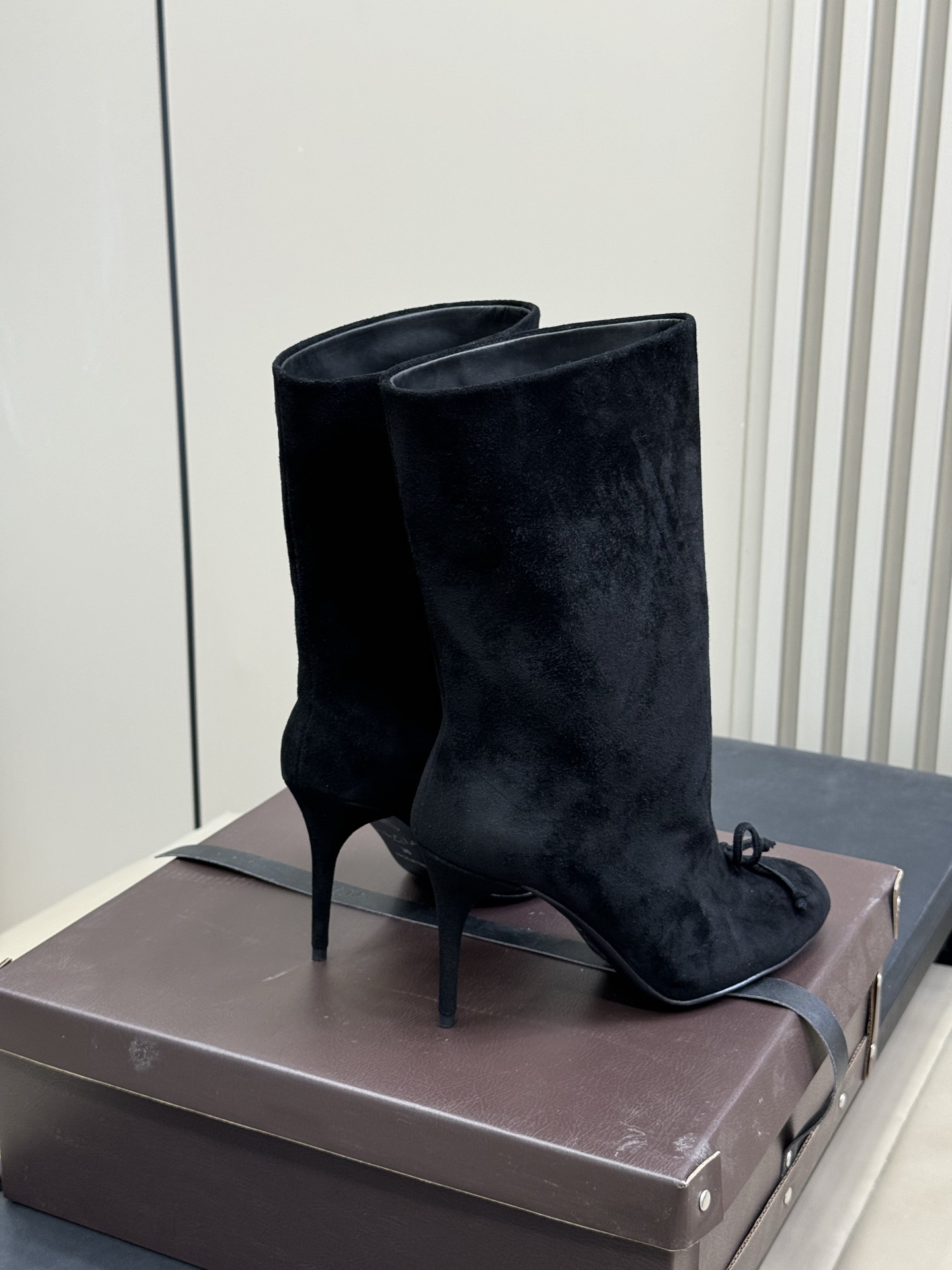 
ALAIA｜易梦玲同款高跟短靴
该款黑色小牛皮高跟短靴，正面点缀装饰蝴蝶结，搭配90毫米鞋跟与22厘米