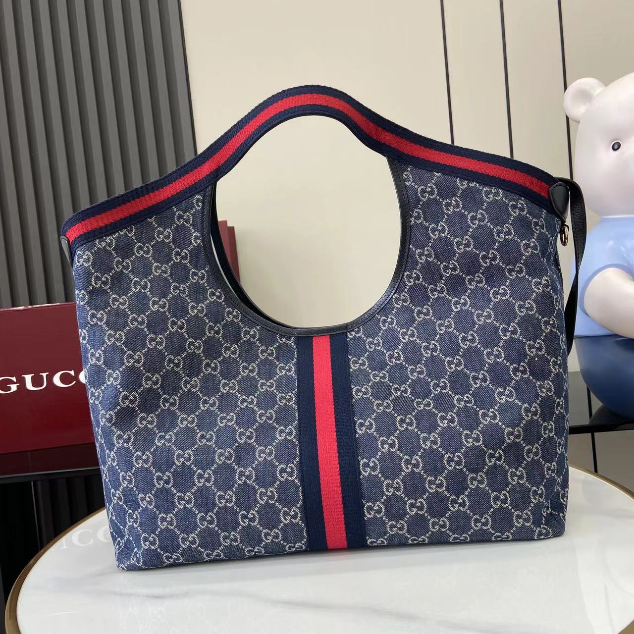 p580。《配全套原厂专柜包装》【新品】Gucci Giglio系列全新亮相佛罗伦萨2026早春时装秀，致敬品牌意式根源，融合隽永传承与革新精神。这款大容量托特包采用GG丹宁面料匠心打造，缀饰织带滚边，并配有一个可拆卸的手拿包。
蓝色和白色GG丹宁
饰蓝红织带滚边
浅金色调配件
棕色棉布衬里
双G
配可拆卸手拿包
顶部提手：18厘米高
磁扣开合
型号：853971。
尺寸60厘米（宽） x 47厘米（高） x 16厘米（深）
重量：约0.6千克
颜色：蓝牛仔/蓝皮。
意大利创作